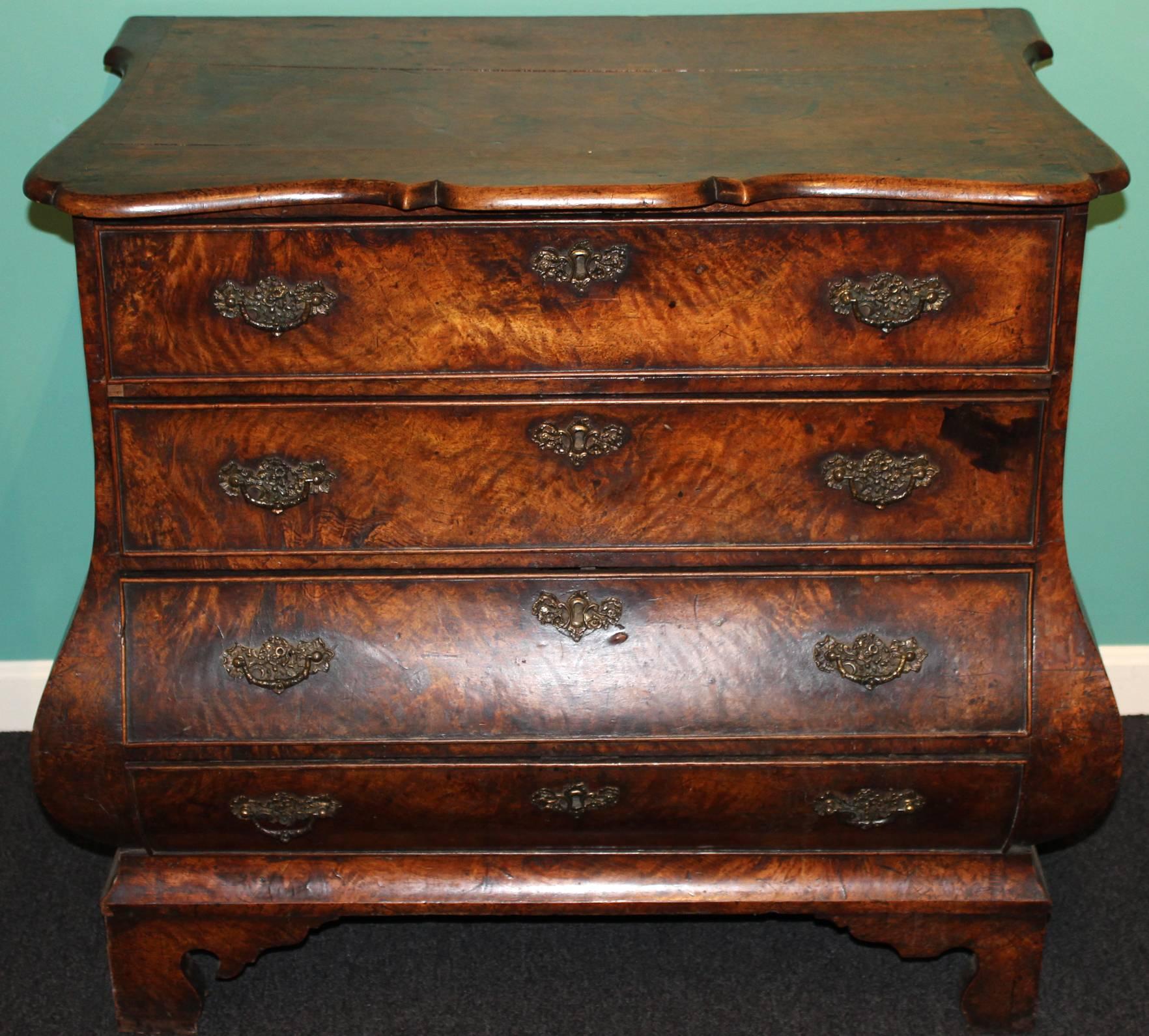 A diminutive Dutch or German bombe oak and walnut four drawer chest. The nicely shaped and moulded top above a case of four drawers with swelled, or bombe, lower section and all raised by four bracket feet. Overall nice patina and color with great