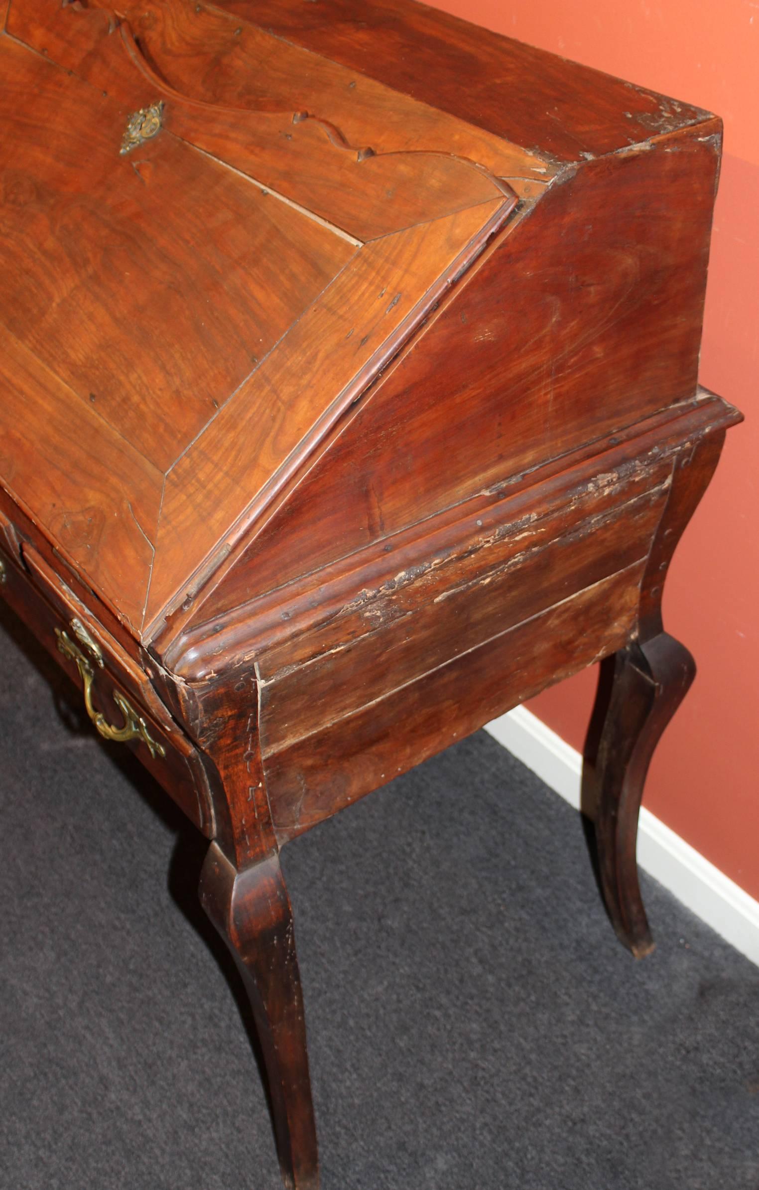 An 18th century Italian walnut ladies desk with gallery interior consisting of seven drawers and four compartments, including a fifth secret center compartment under the writing surface. The lower case has two fitted short drawers also used to