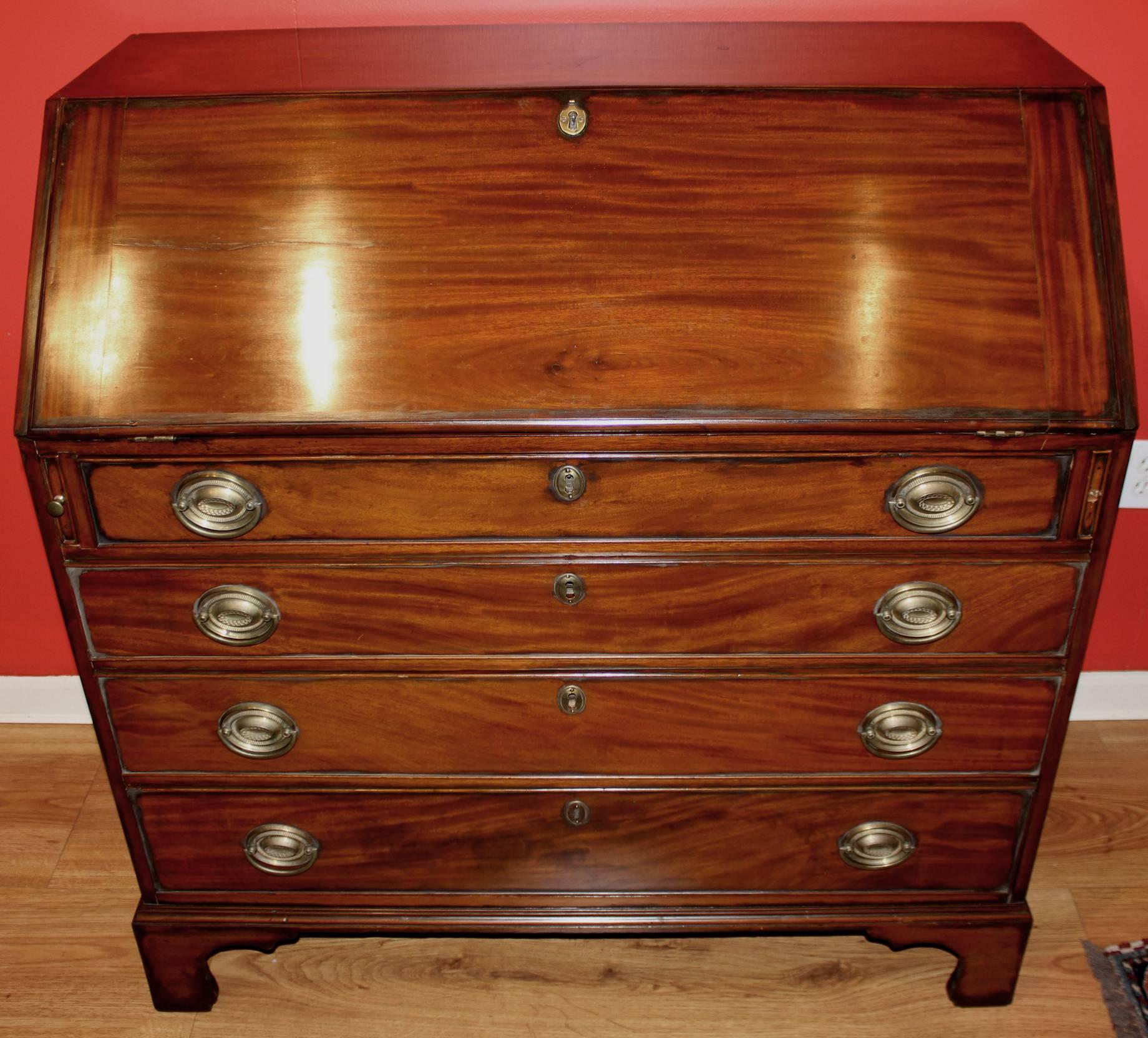 A fine American federal mahogany slant front desk with compartmentalized interior, including six drawers and eight valanced pigeon holes, over four graduated drawers, all supported by nicely proportioned bracket feet. Appears to have retained its