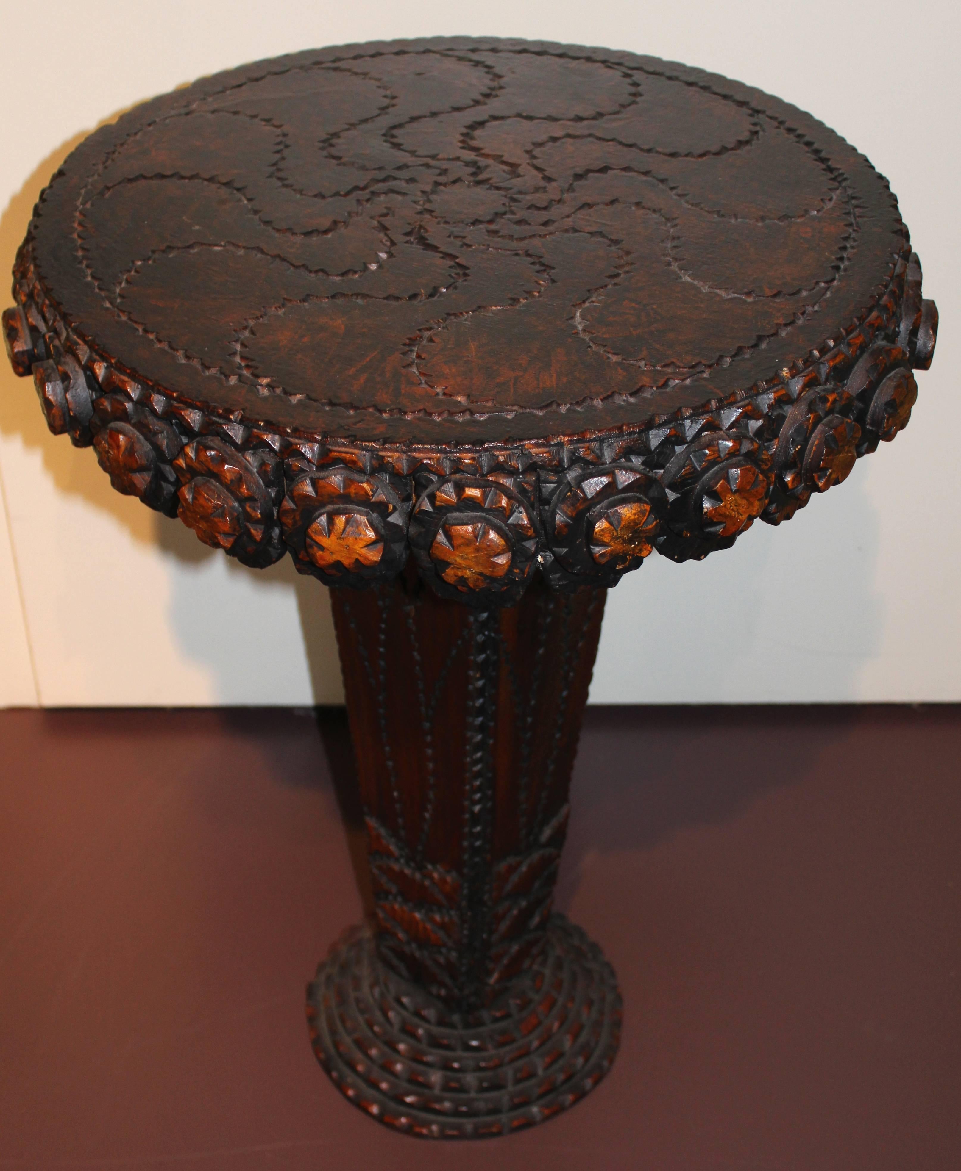 This wonderfully carved wooden tramp art table was carved by the group known as the Hermitage Artists. This group of artists began in New York with five men: Michael Lavery, Andy Stutter, Jim Kennedy, Paul Cunningham, and Ira Rogoff. This group of