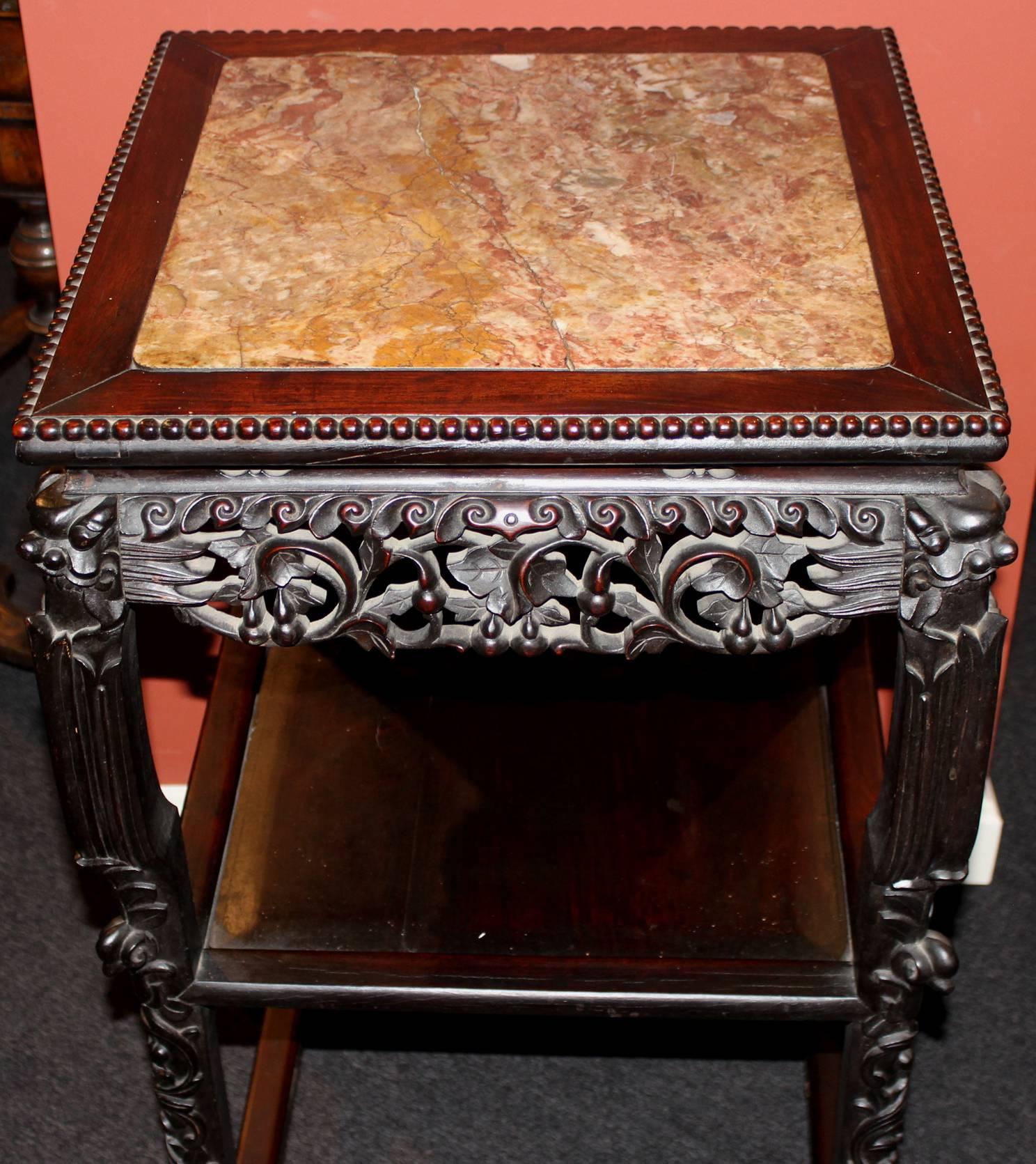 A fine example of a Chinese rosewood stand with medial and lower shelf or tier, inset marble top with crack, and beautifully carved apron and legs. Dates to the 19th century.