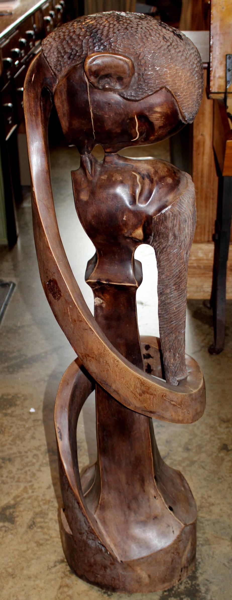 A nicely carved African hardwood abstract statue of a man and woman kissing, dating to the 20th century, with nice form, detail, and patina.