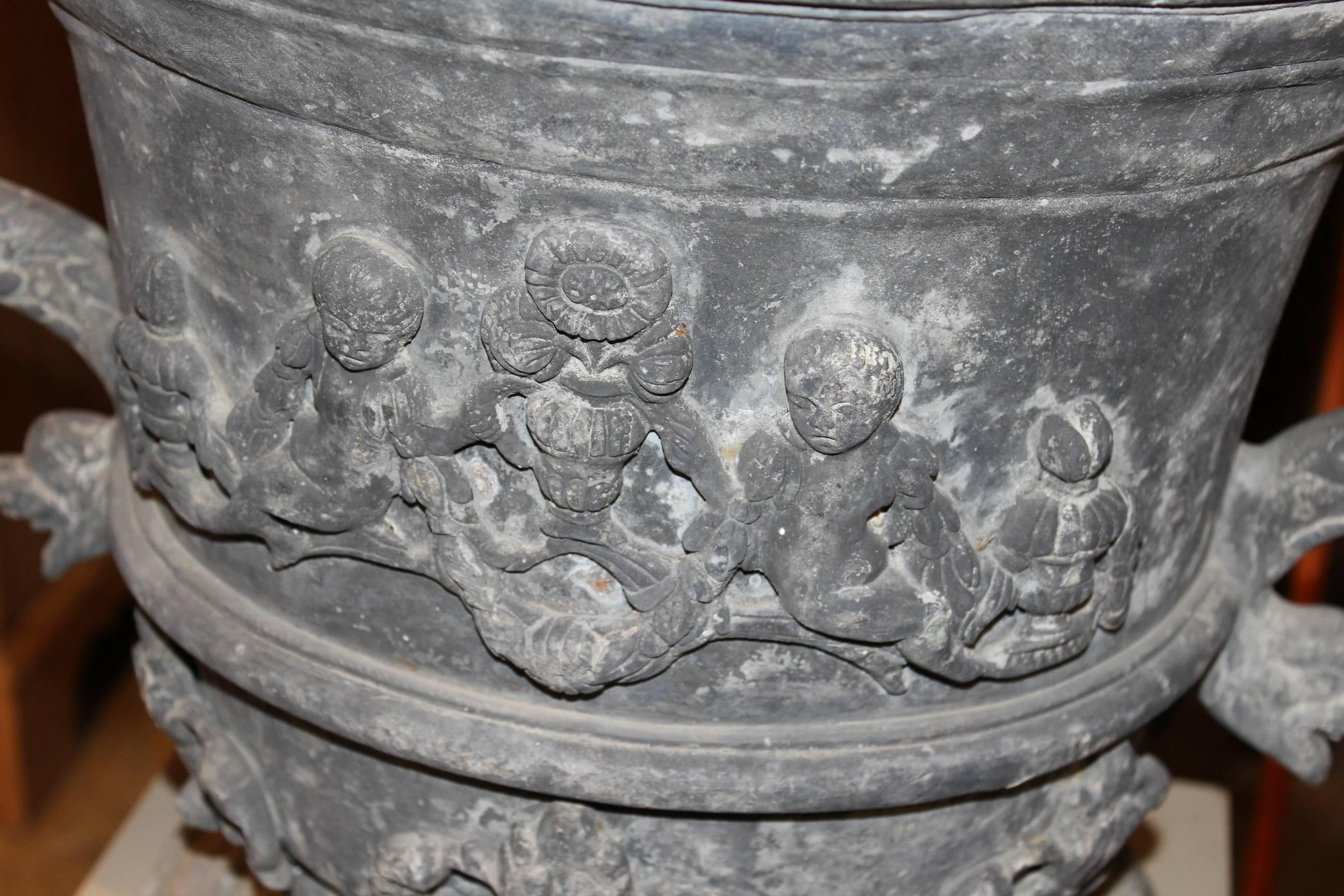 20th Century Pair of Lead Urns with Figural Handles and Cherub Decoration