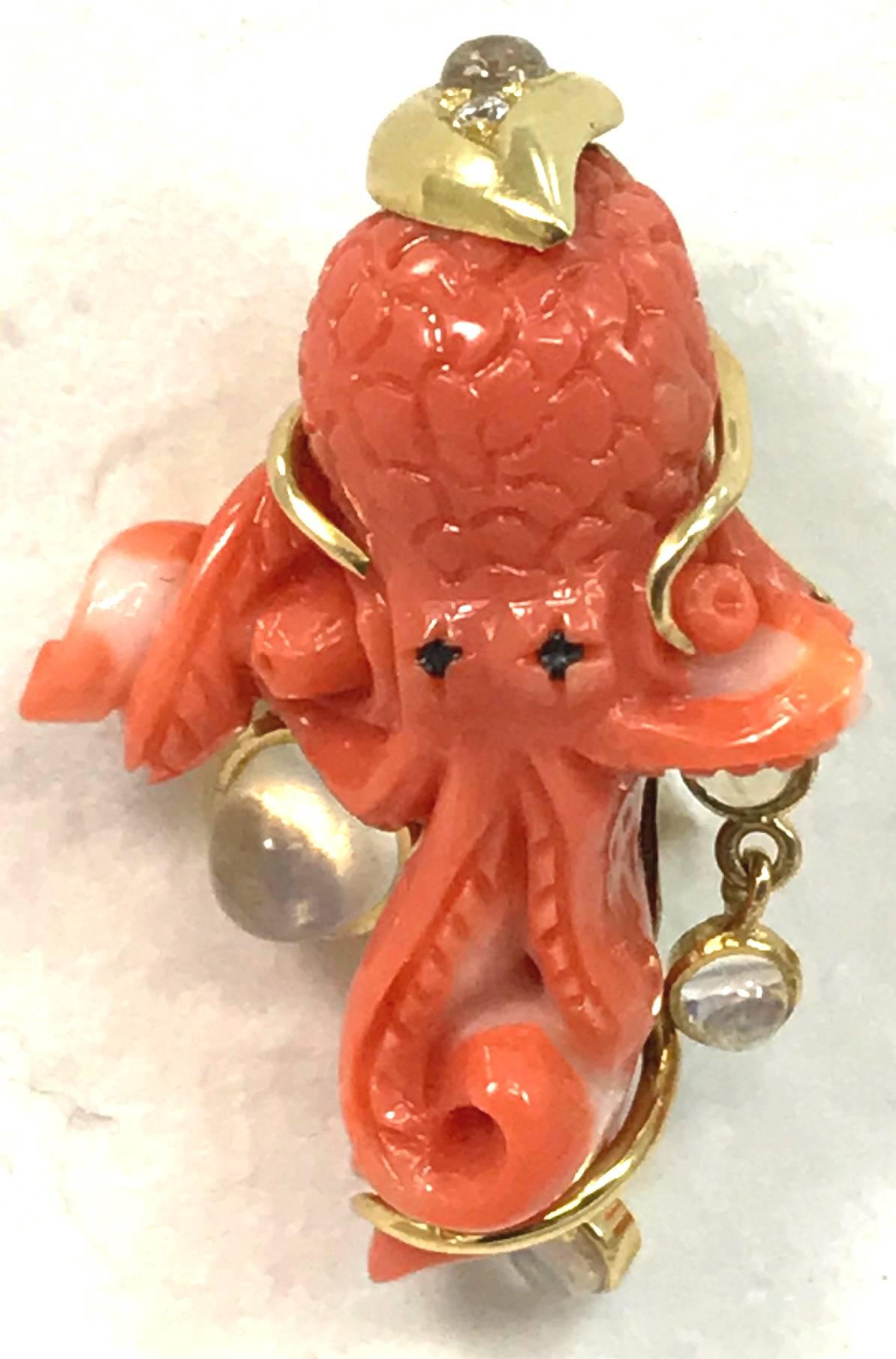 This is a one of a kind pair of spectacular carved coral octopus clip pierced earrings set in 18 karat gold with gold encased moonstone dangles and small diamonds decorating the top of each, created by New York jewelry designer Marilyn Cooperman,