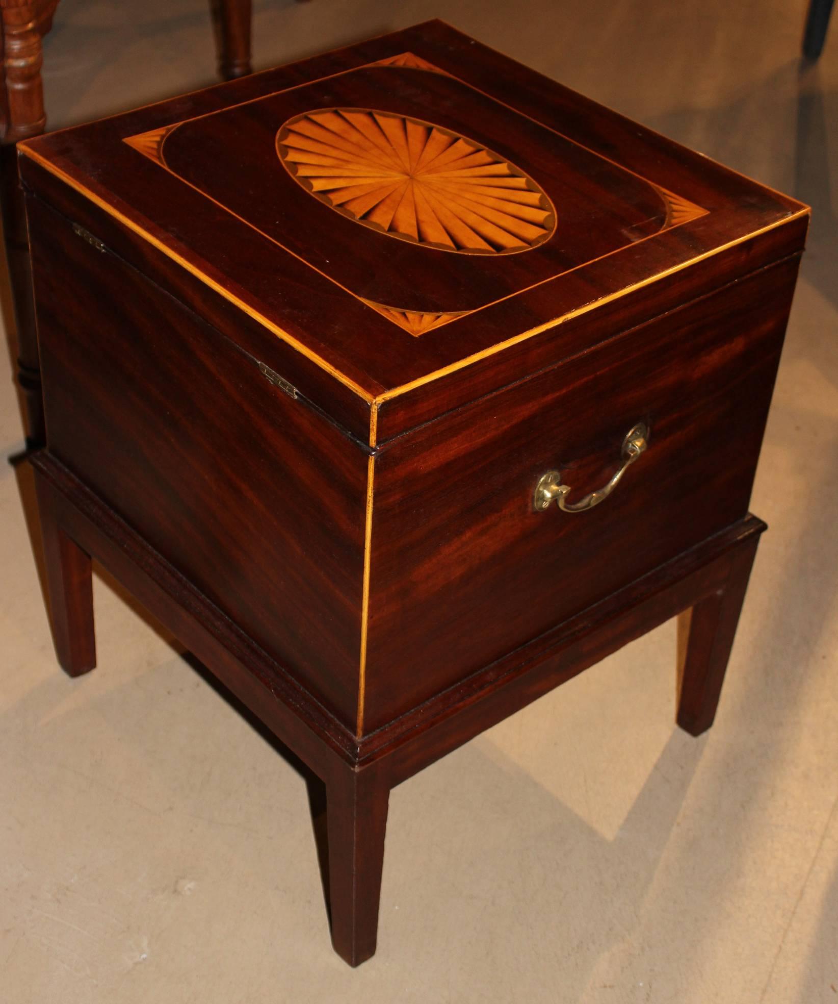 A splendid late Georgian mahogany cellarette wine cooler on attached stand with superb inlay and ribboning to the grain of the mahogany. Perfect size for diminutive side table.