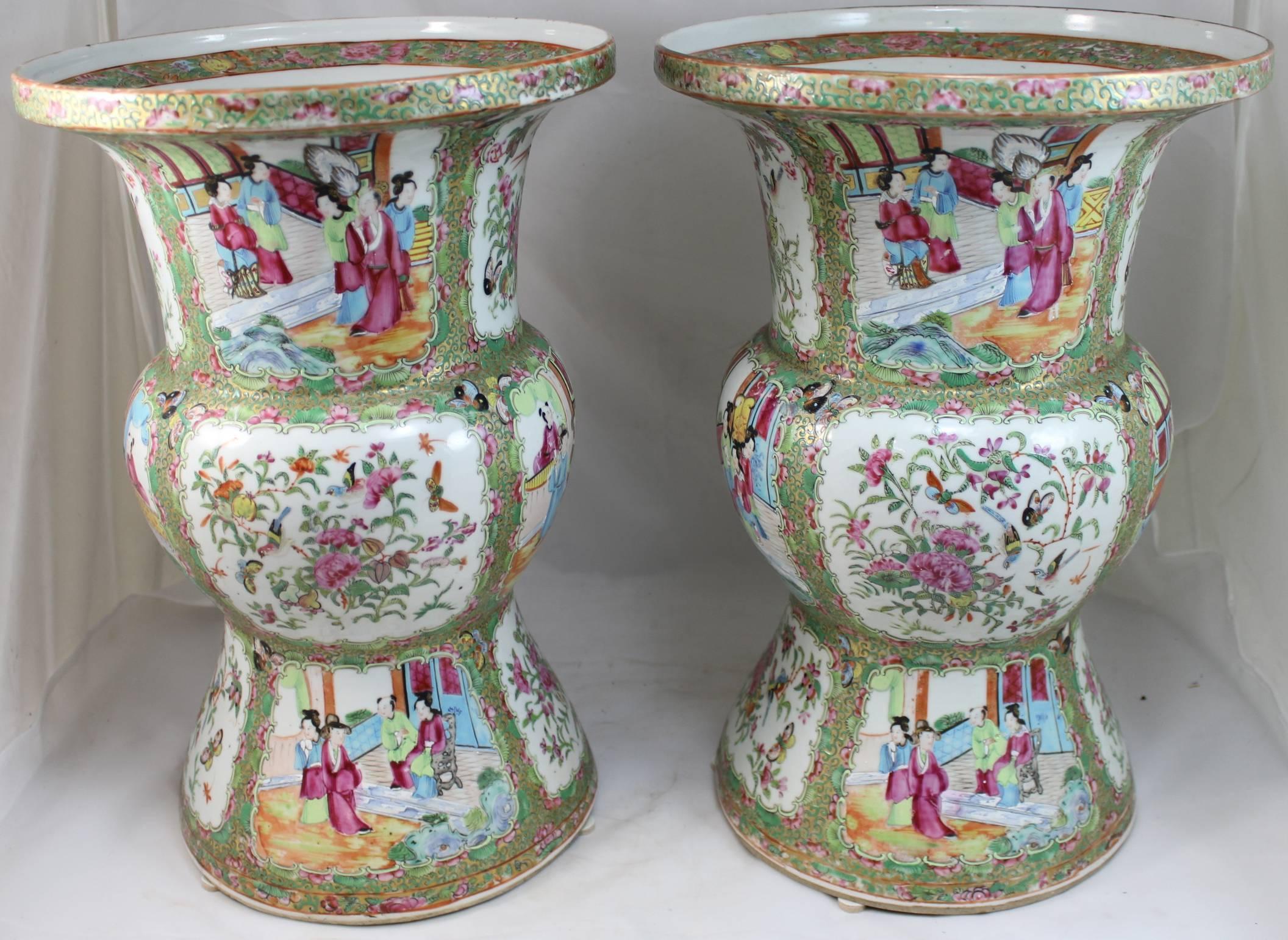 An exceptional pair of Rose Medallion Ku form vases, with four exterior alternating panels of figures and foliate scenes with birds and butterflies on each of the three sections of the vases. Superb quality.