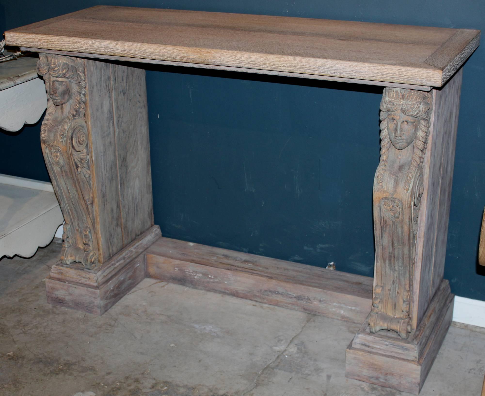 An exceptional wood French Empire style console constructed around two beautiful 19th century, Continental caryatid figures and scroll front carved elements, with custom rectangular top and fitted U-shaped base. Great surface.