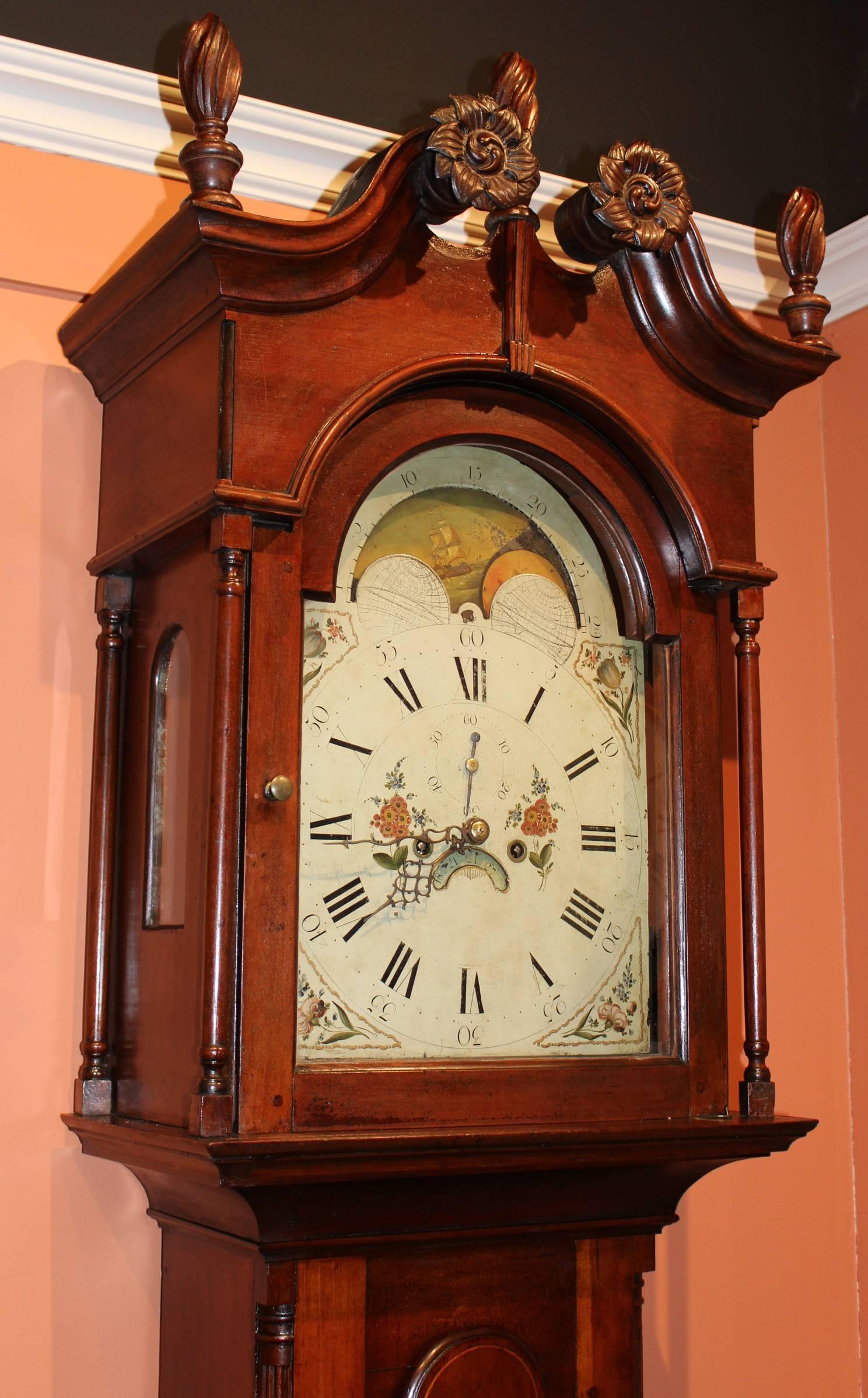 A beautiful carved cherry tall case clock, unsigned, probably 18th century Pennsylvania origin, with painted metal dial with moon phase. Roman numerals with floral spandrels and center decoration, calendar aperture and seconds subsidiary dial. The