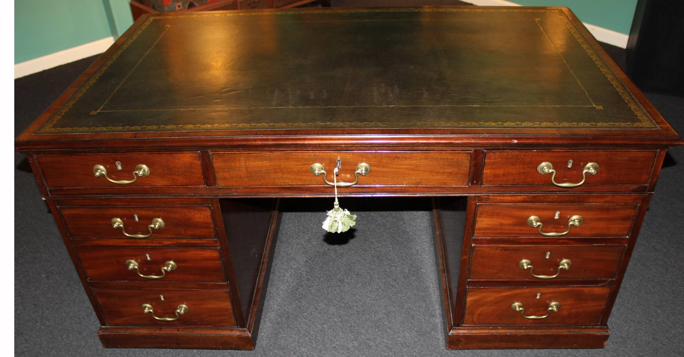 An exceptional Georgian English Chippendale mahogany partners desk. The rectangular top with gilt-tooled leather writing surface, above three frieze drawers, the same on reverse. The pedestal bases each with three drawers on both sides with bold