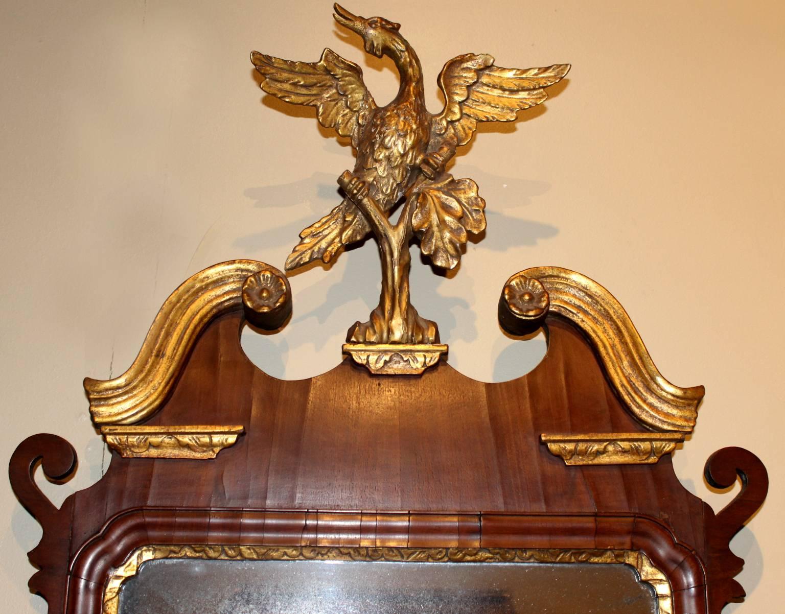 This Chippendale mahogany and gilt Constitution mirror features gilded side leaves and a carved and gilded arched crest with floral rosettes and a beautifully carved phoenix bird. Fine condition and original gilt, American or English, circa 1770.