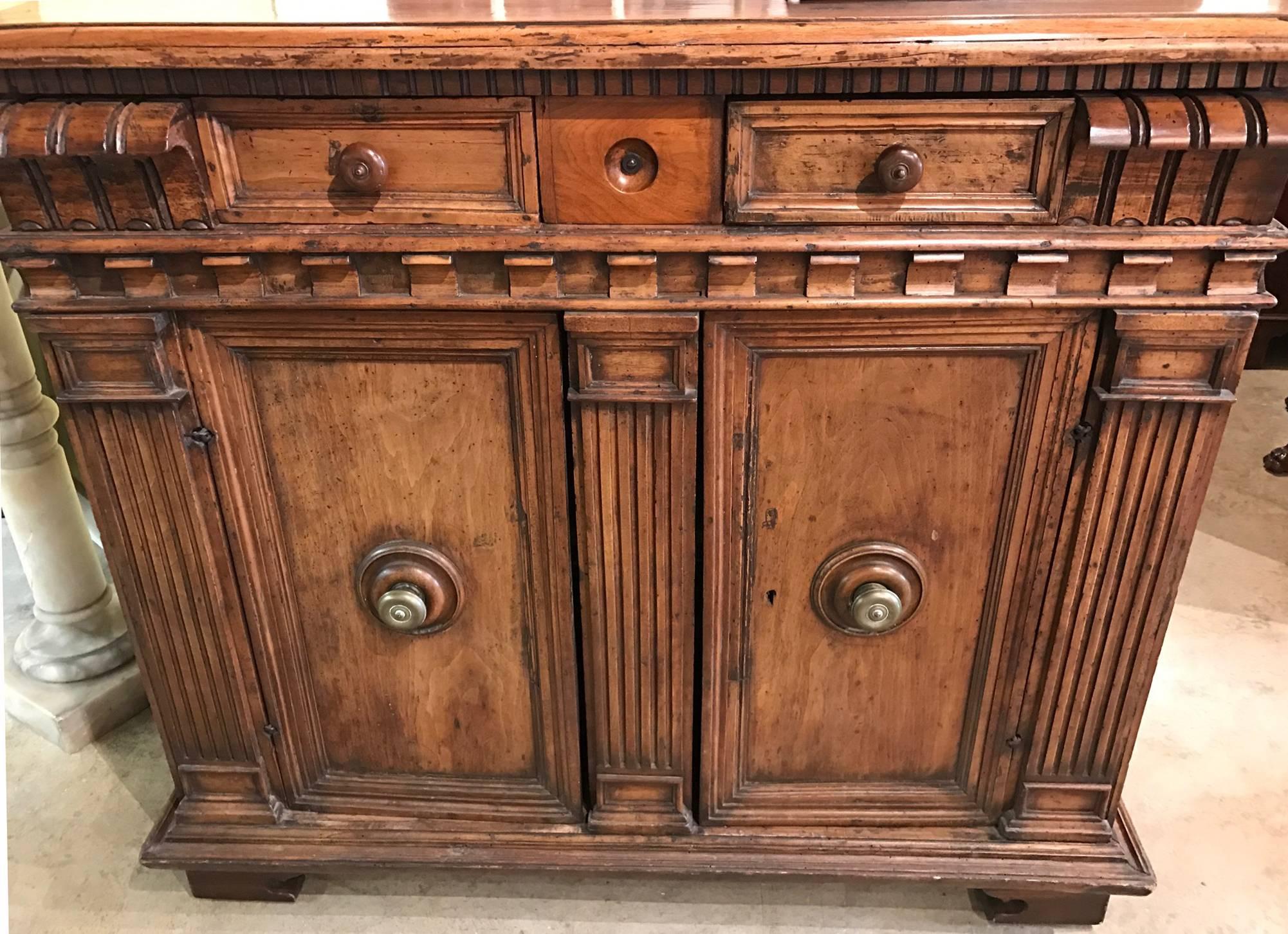 A fine 18th century Italian walnut cupboard with a great form, rectangular molded edge top over three fitted small drawers, surmounting two paneled doors which open to reveal a single interior shelf, all supported by a molded edge base. An