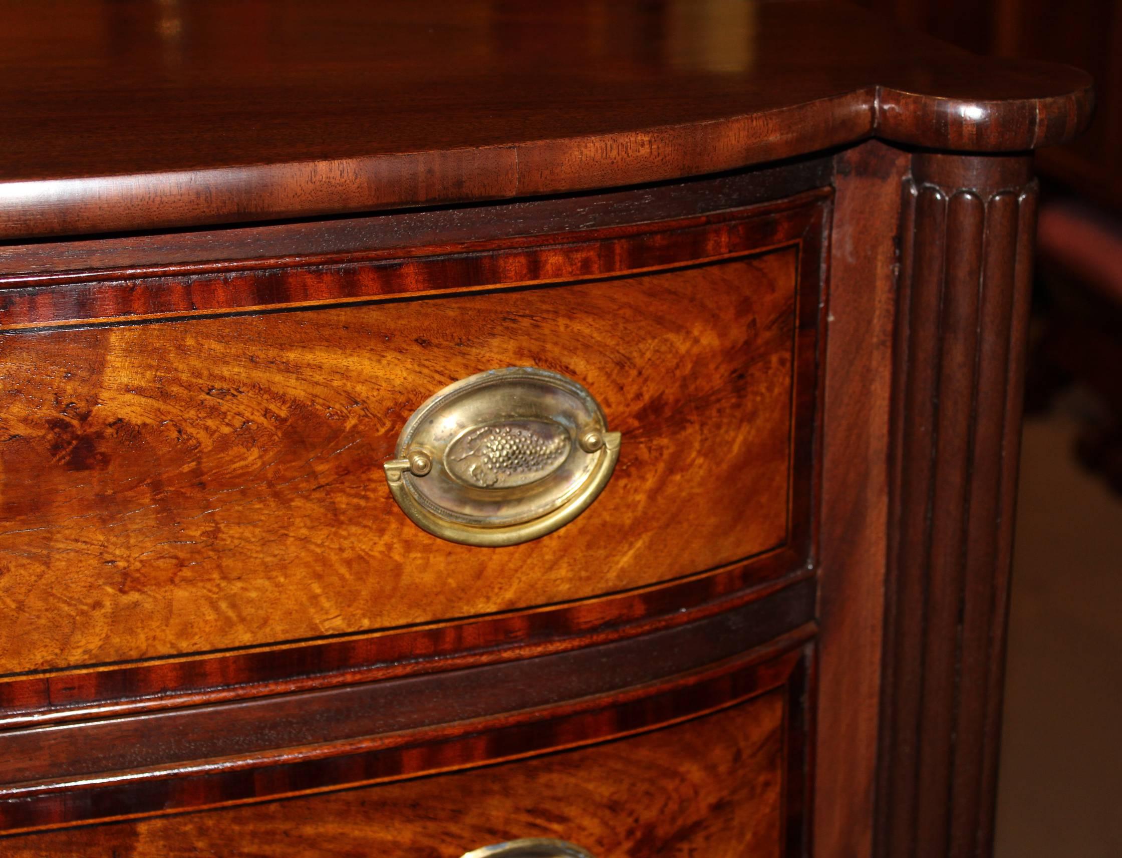 An exceptional Federal period Sheraton mahogany four-drawer chest, probably Portsmouth NH, with shaped top, turret corners over reeded pilasters, drawer fronts with bookmatched flamed birch and crossbanded mahogany veneers, replaced brasses,