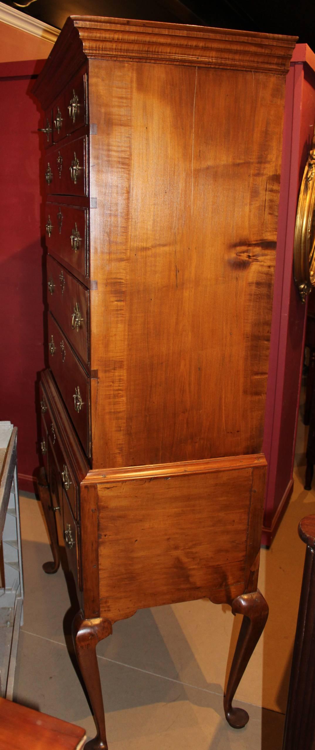 A fine two part 18th century Queen Anne tiger maple highboy, probably made in New Hampshire, its upper case with molded cornice surmounting three fitted short drawers over four graduated long drawers, and associated lower case with single long