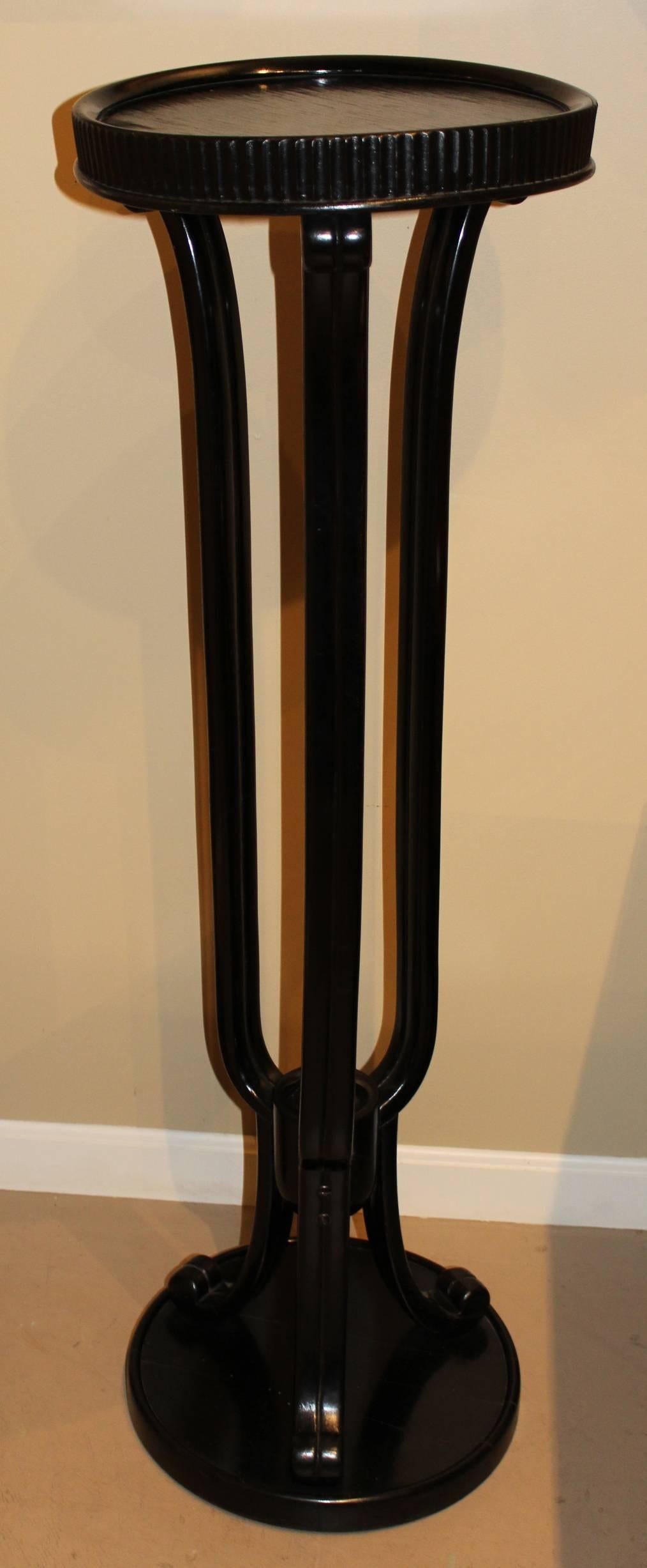 A tall ebonized wooden pedestal, probably beechwood, with great form, designed by Otto Prutscher (1880-1949) for Thonet, circa 1910. Elegant scrollwork with three long, slender support legs between a round top and base. This stand design was