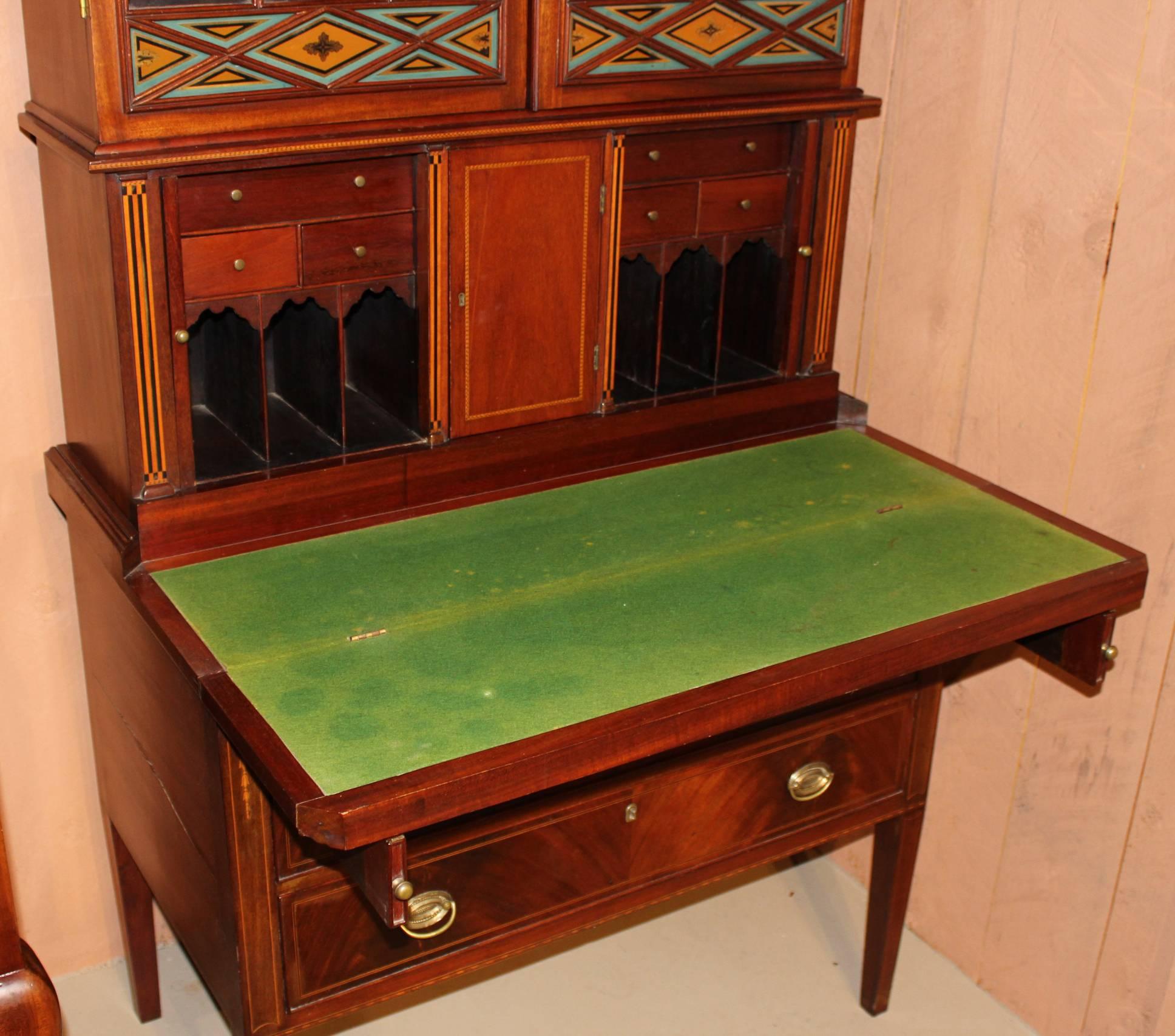 An exceptional three-piece Massachusetts (possibly Boston) Federal Period Hepplewhite mahogany inlaid secretary in three parts. The upper section with
stepped crest and finials surmounting a molded frieze above Gothic glazed doors with geometric