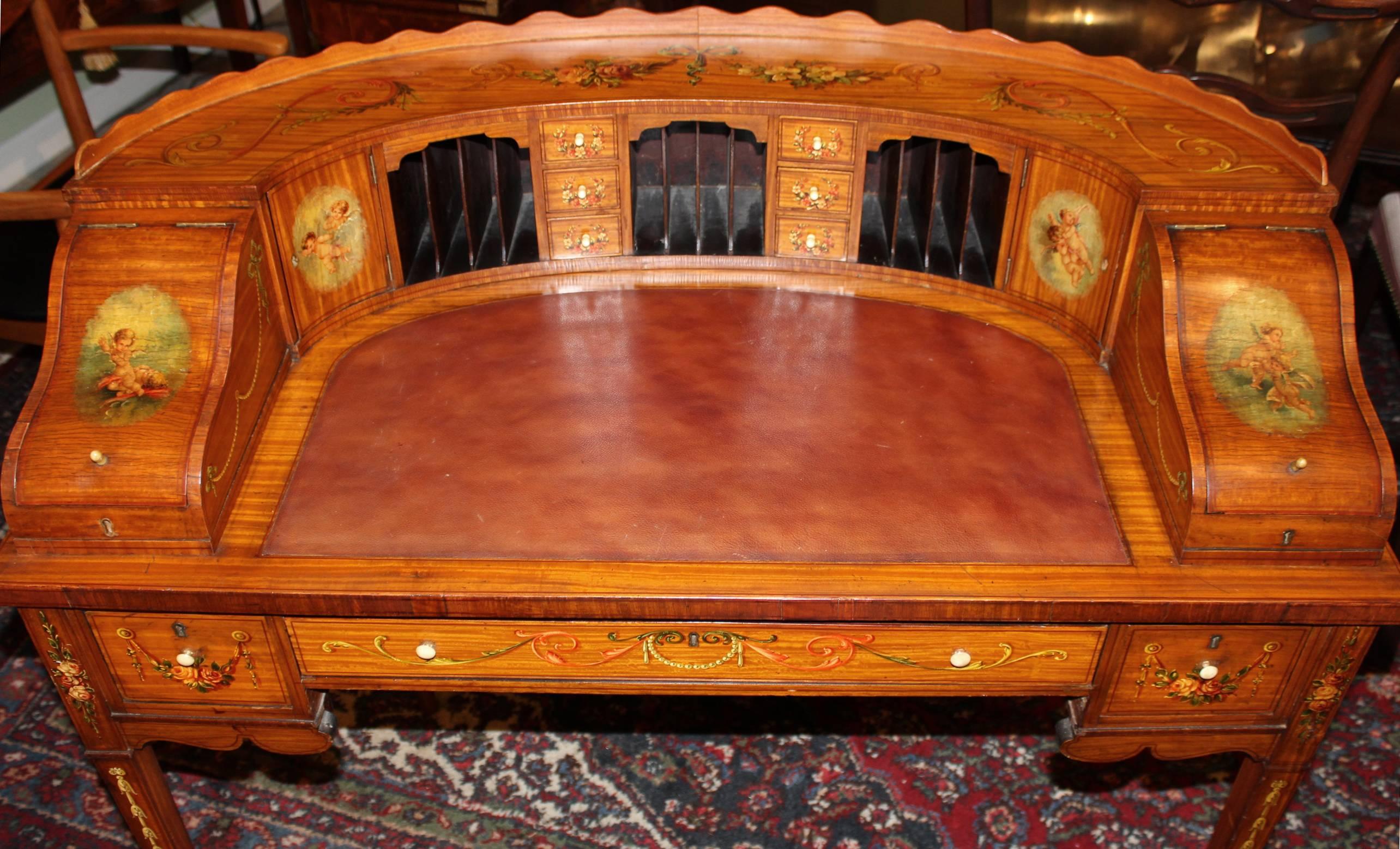 A spectacular custom-made Edwardian style hand-painted Carlton desk in satinwood and mahogany with fitted leather writing insert, compartmentalized surround with six small drawers and three valanced cubby sections, flanked by two fitted single door