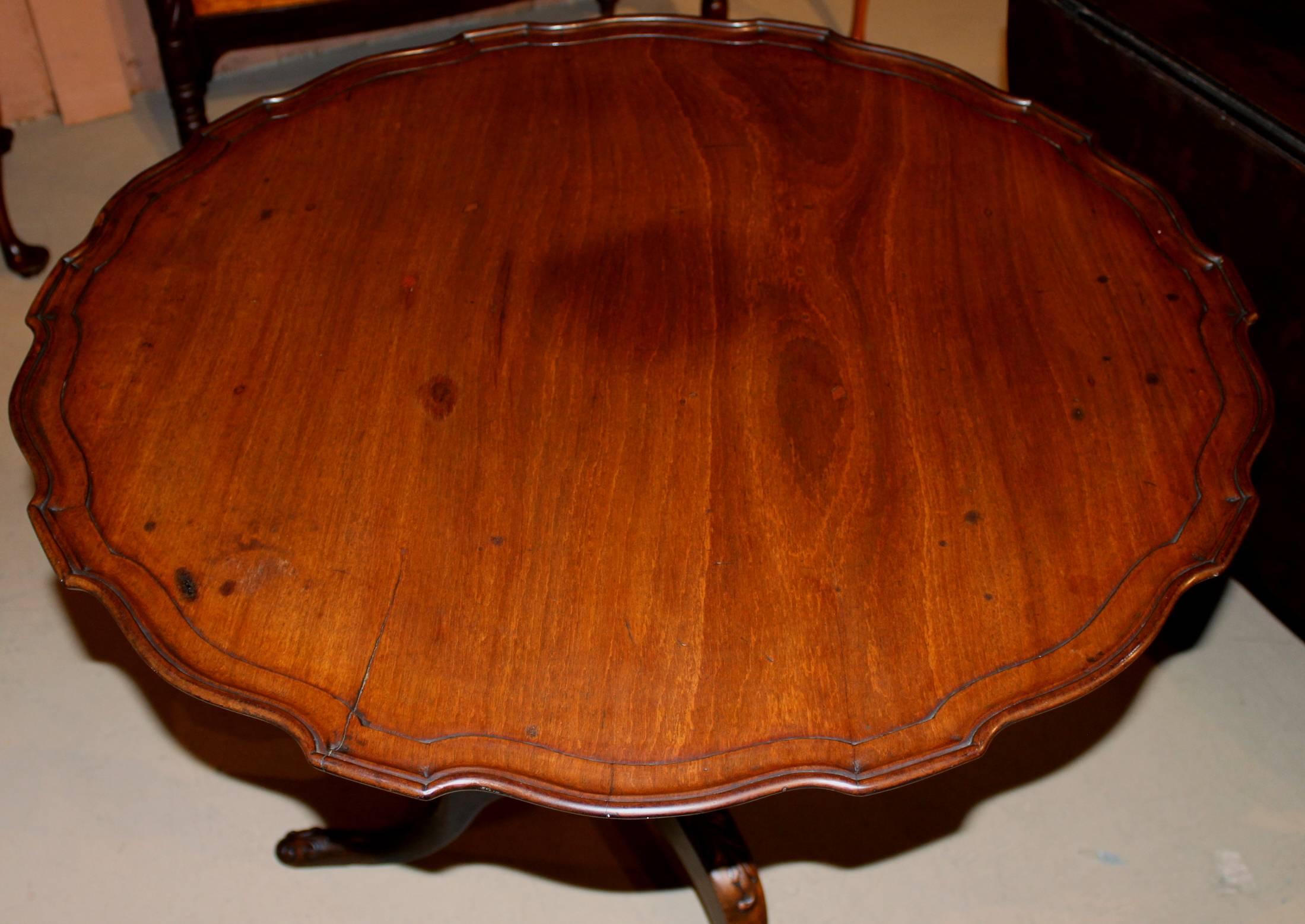 A fine example of a Georgian carved tilt-top tea table in mahogany with pie crust edge, with bold, foliate carved acanthus pedestal and cabriole legs, terminating with carved pad feet, 18th century English, with its original locking mechanism. Very