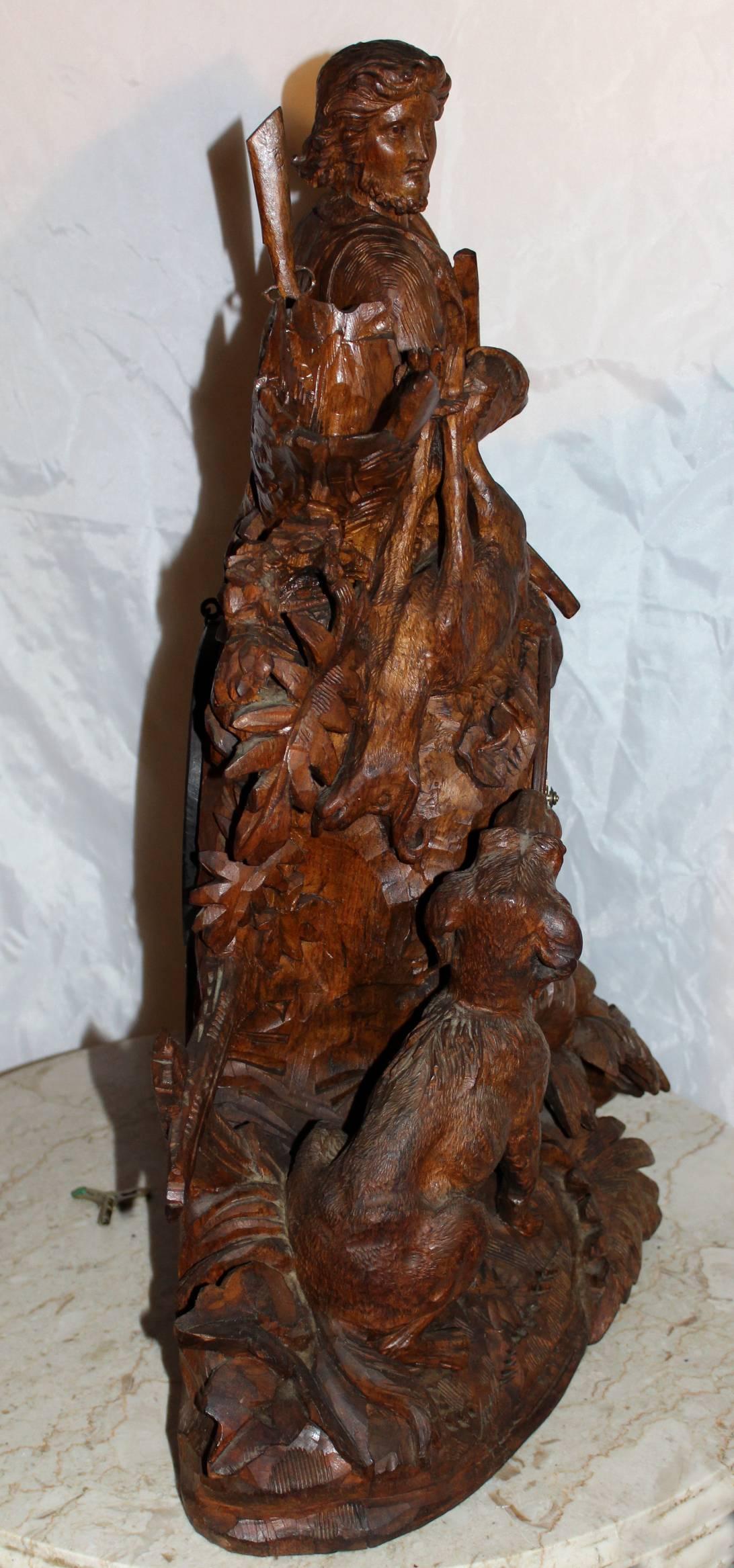 Allemand Pendule de cheminée ou d'étagère monumentale sculptée de la Forêt-Noire avec chasseur et chien