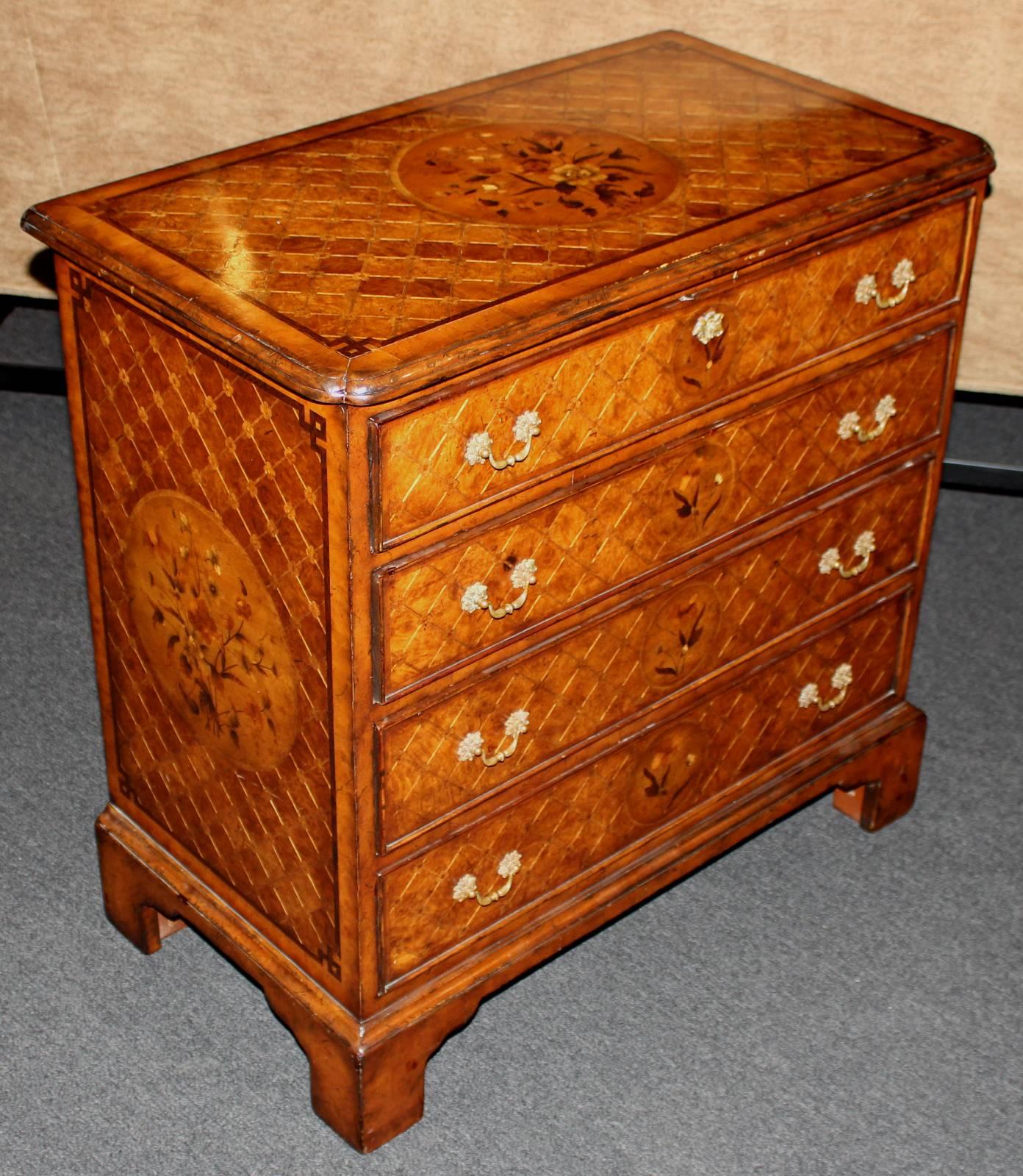 An exceptional diminutive English four-drawer chest with extensive floral and diamond inlay, rectangular molded top with pinched corners, sides and drawer fronts all with banding, centered by pateraes. The chest is constructed in mahogany, with