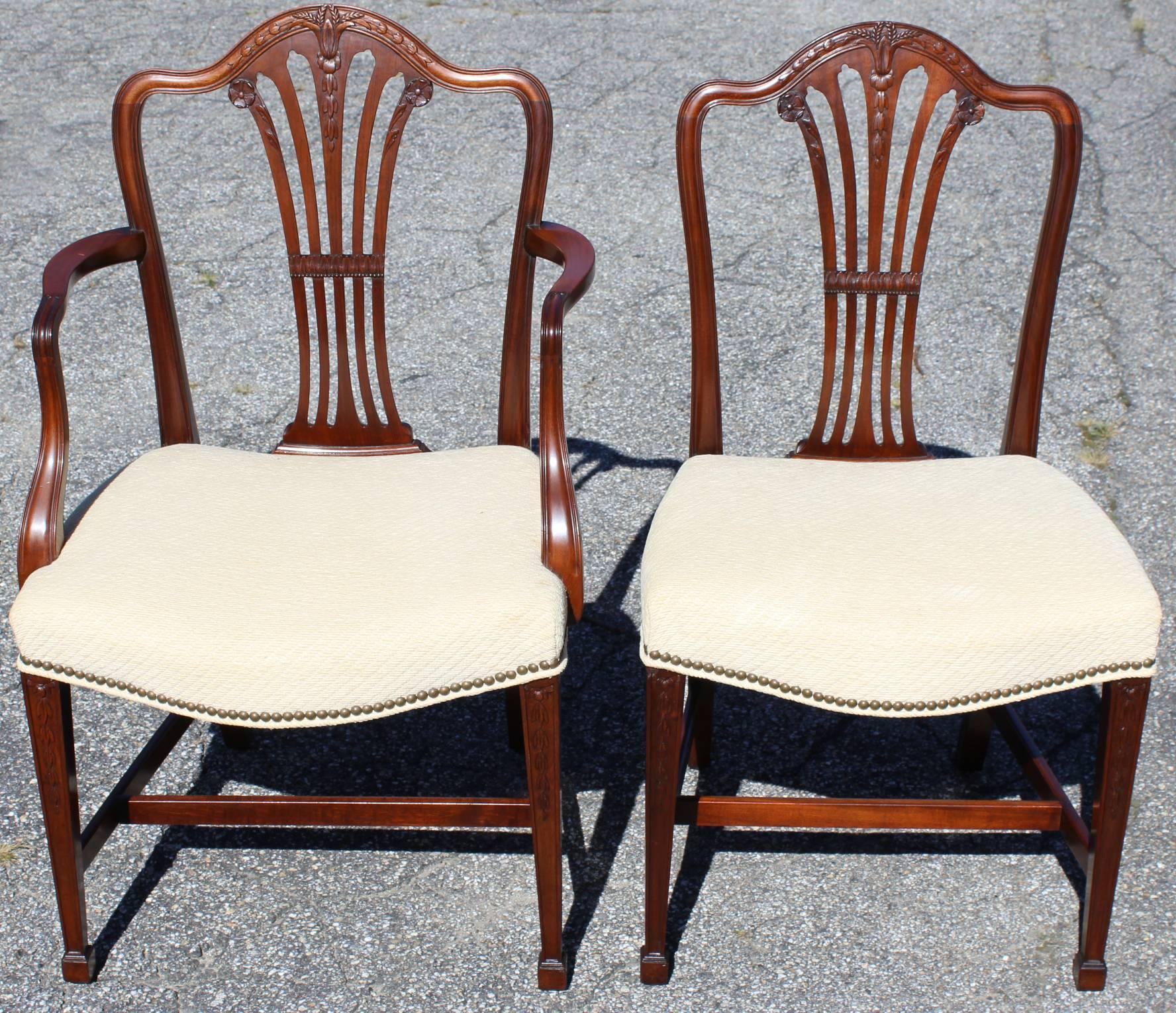 A fine solid set of eight mahogany dining chairs, two armchairs and six side chairs, with carved bellflower decoration on the splats and legs, and cream upholstered fabric seats. Each chair has an incised four digit number, and one armchair has a