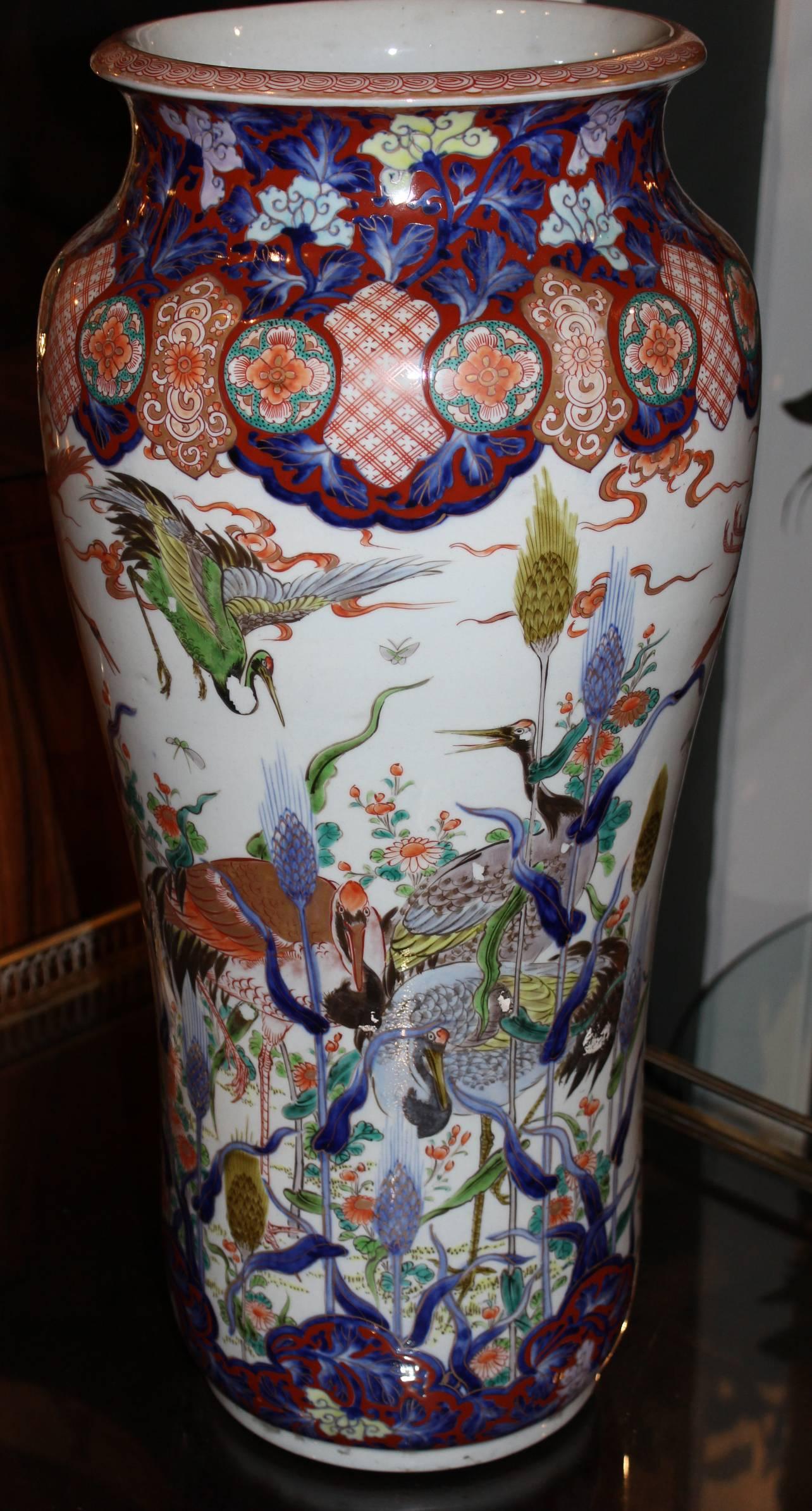 A splendid form Japanese polychrome tall porcelain vase in the Imari palette, featuring scenes with several birds, as well as floral and geometric patterns, signed on base. The vase is in excellent overall condition, with minimal surface wear and