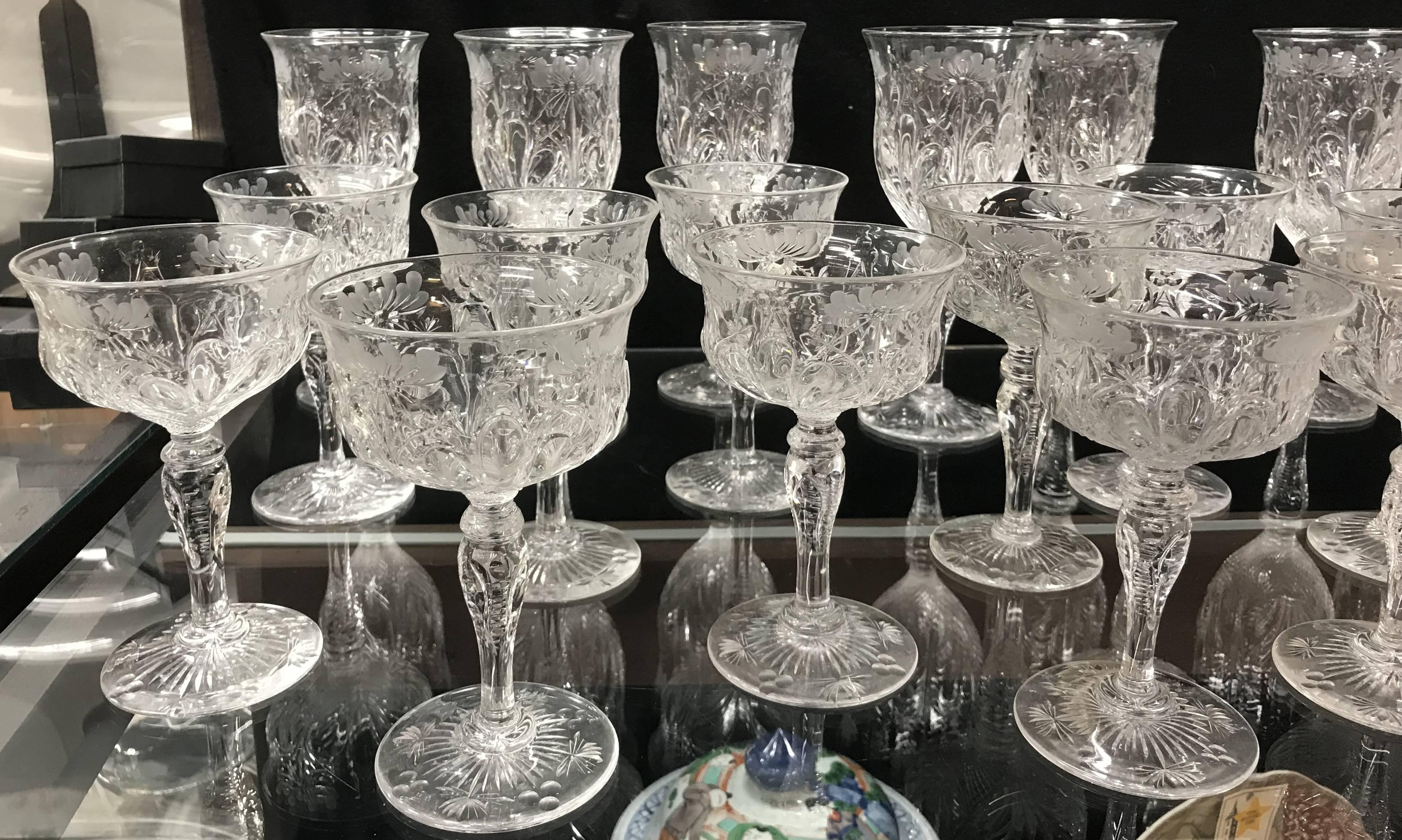 An exceptional quality cut glass stemware set, including 11 water goblets, 11 champagnes, 10 sherries, and 10 cordials, all cut and wheel etched with foliate designs and latticework. Set dates to the 20th century in excellent overall condition with
