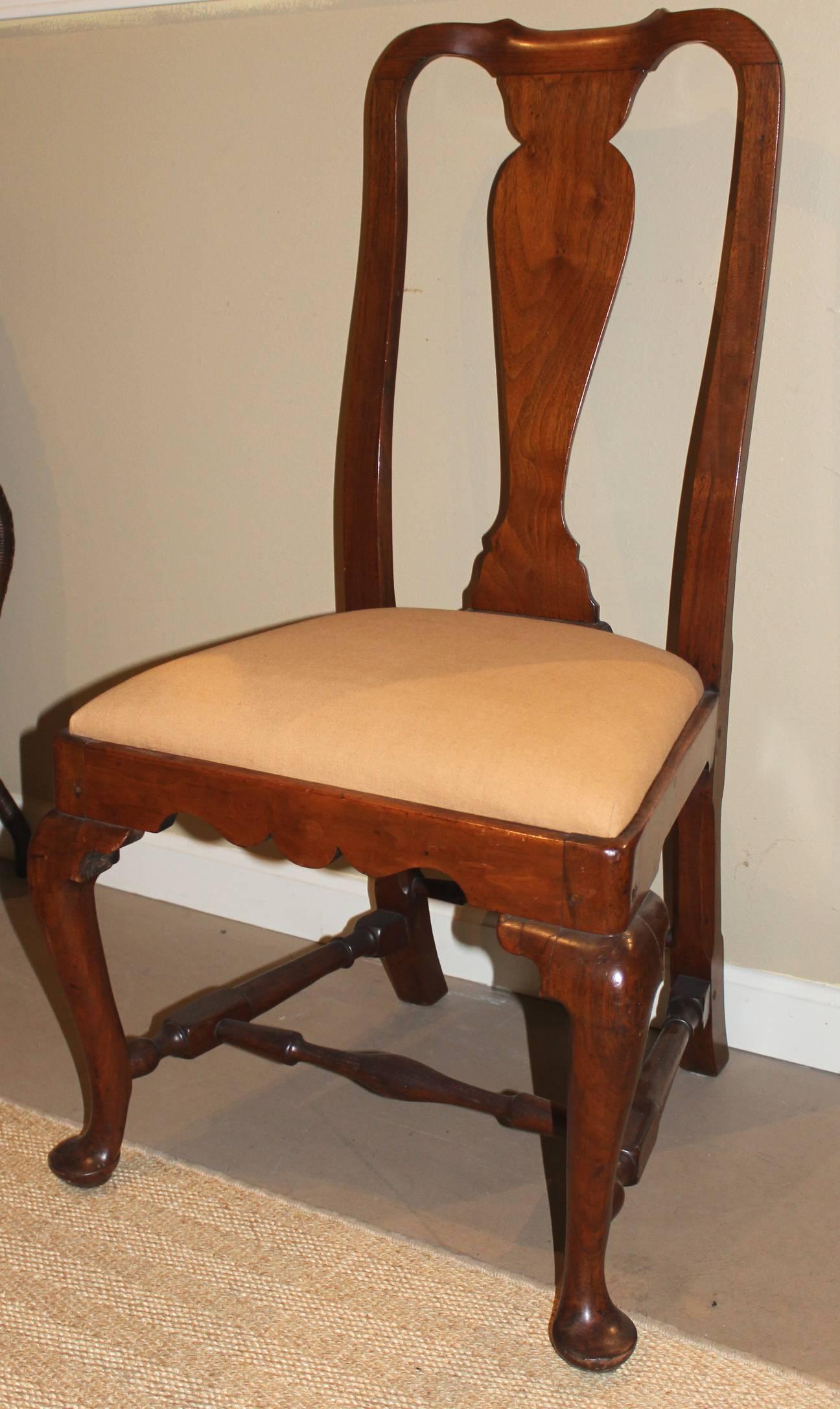 A fine example of a walnut Queen Anne side chair with yoked crest, vasiform splat, cabriole legs with nicely carved front seat rail and turned stretchers, pad feet, and freshly upholstered slip seat. Probably Boston, MA, in origin, circa 18th