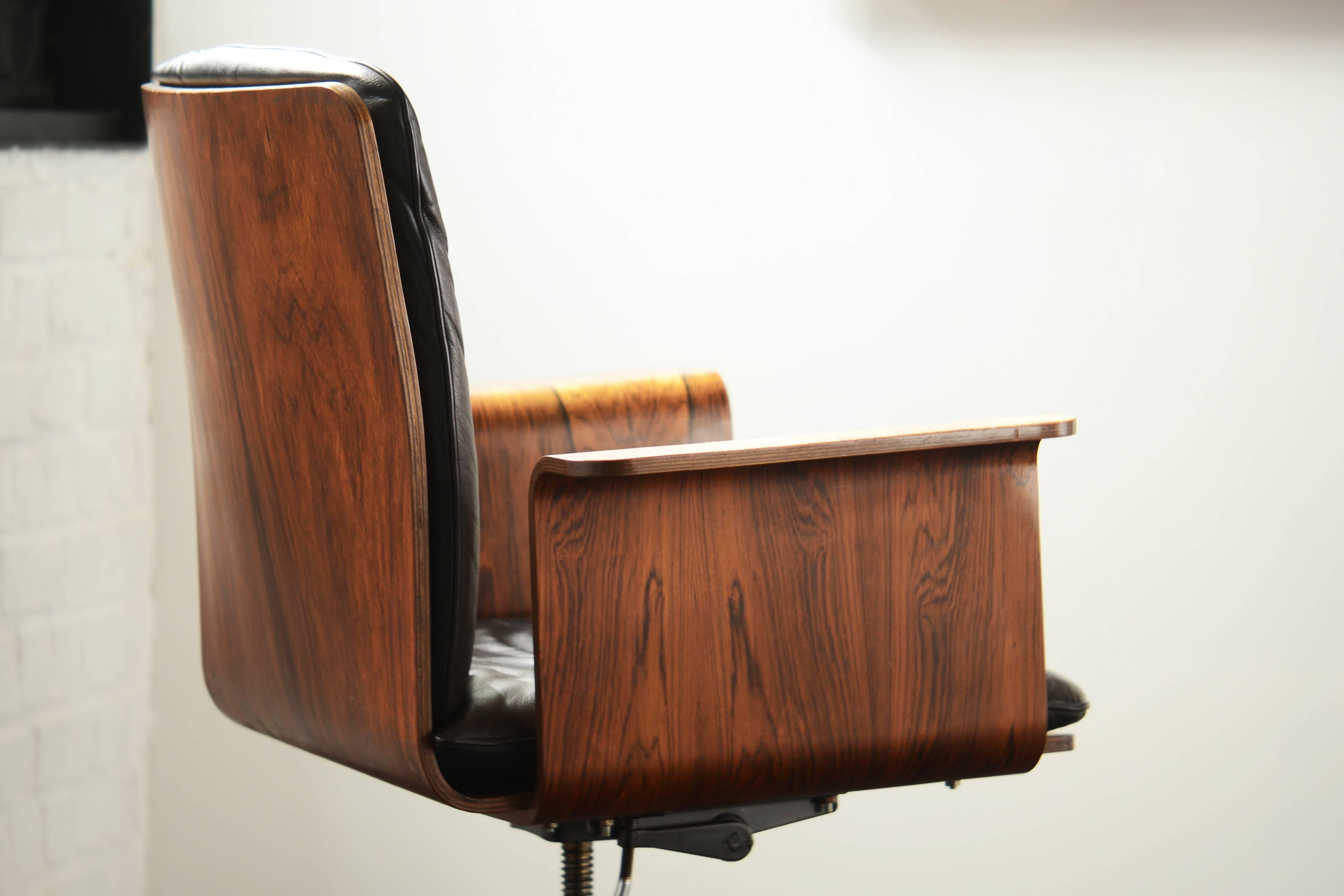Comfortable rosewood and black leather desk chair on wheels. Reclinable and adjustable in height. In very good condition. Nice rosewood desk by Jorgen Hoj to match.