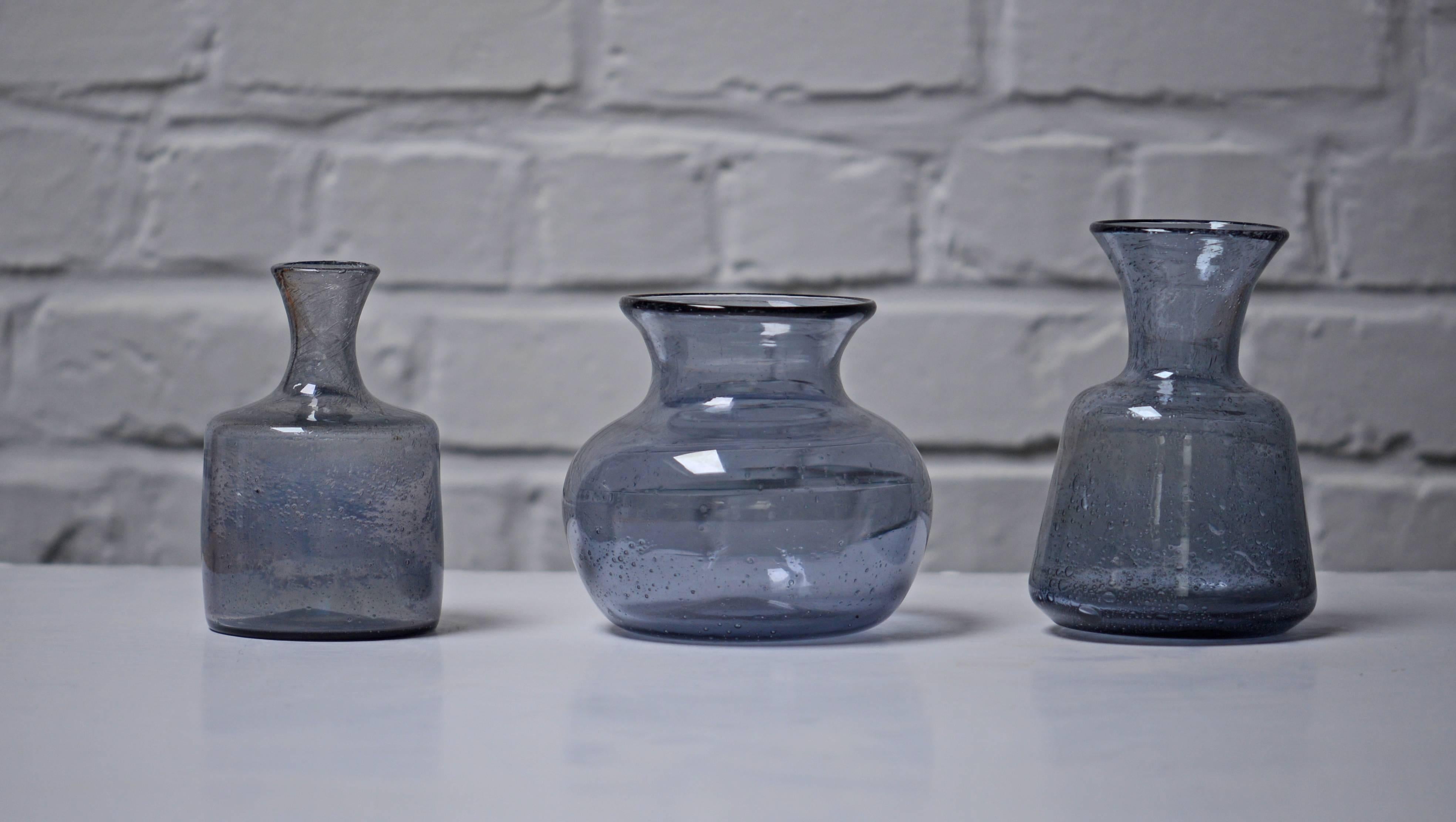 Erik Hoglund handmade vases by the Artist for Boda, Sweden. 

One is grey, on the left. The two others are lila/grey.