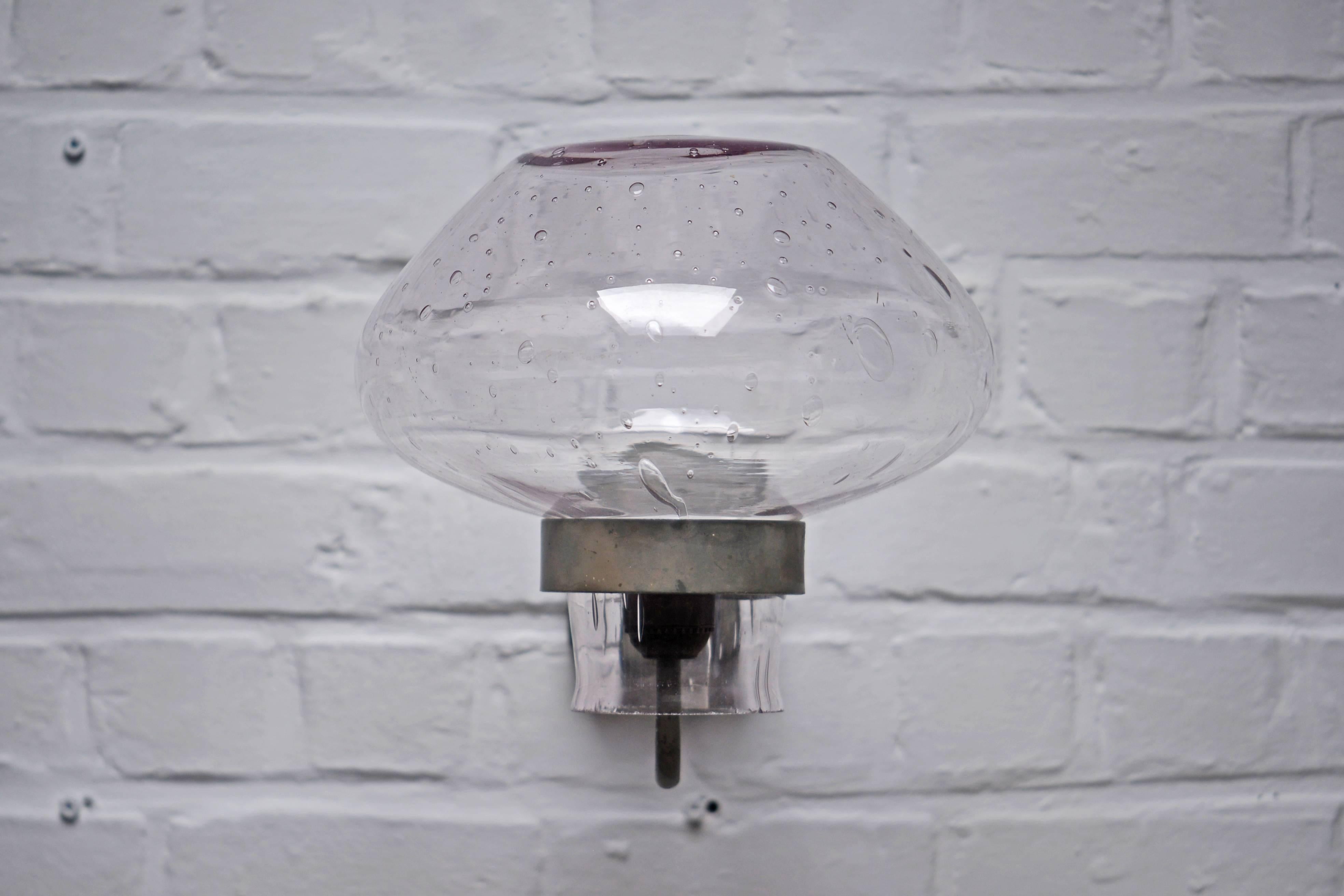 Gunnar Asplund, large wall lamp consisting of a grey painted metal frame and a huge light purple translucide glass globe made by hand. There is many bubbles to the shade that provide a warm grain. It could be used outdoor but indoor as well. Made in