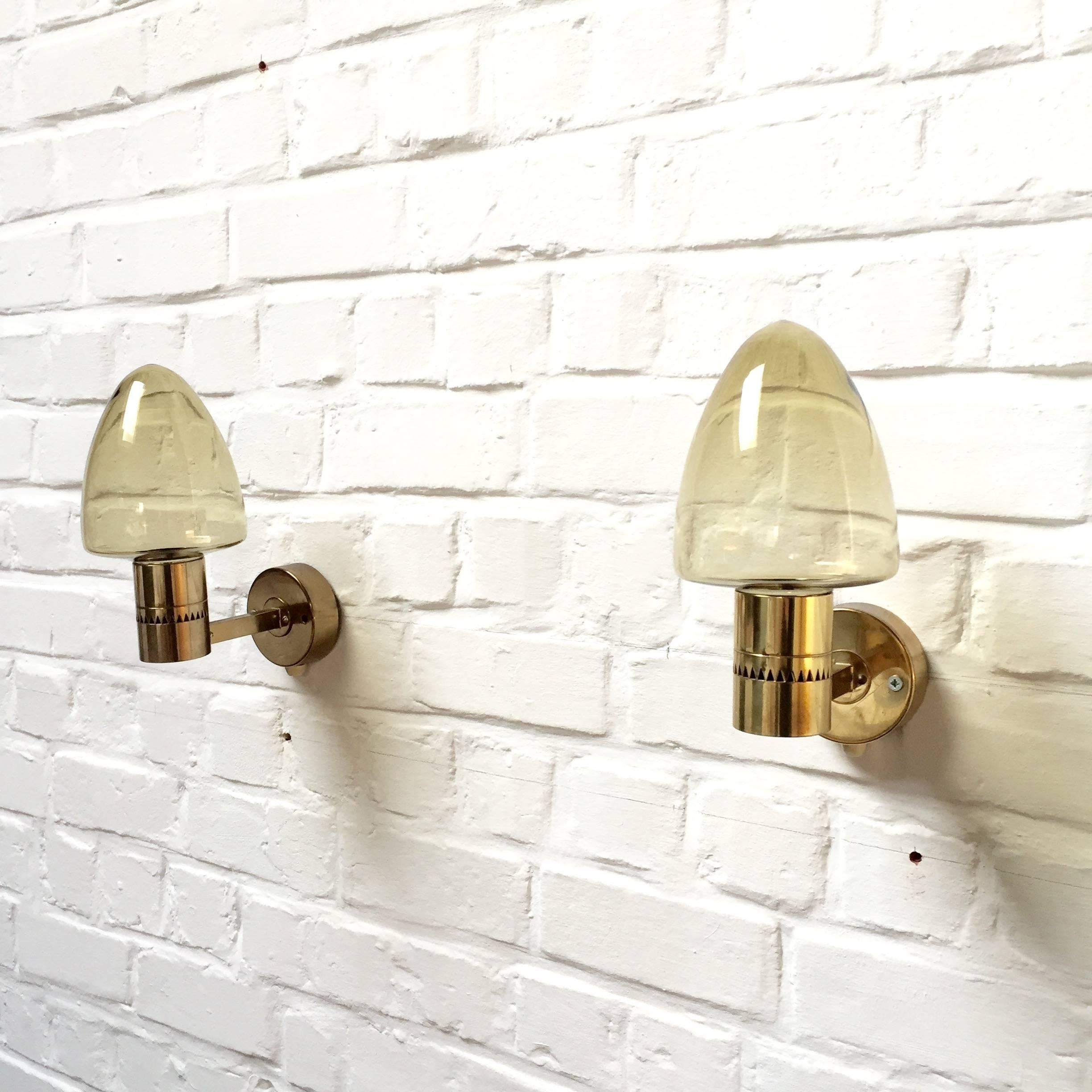 One pair of gold smoked glass and brass wall lamps.