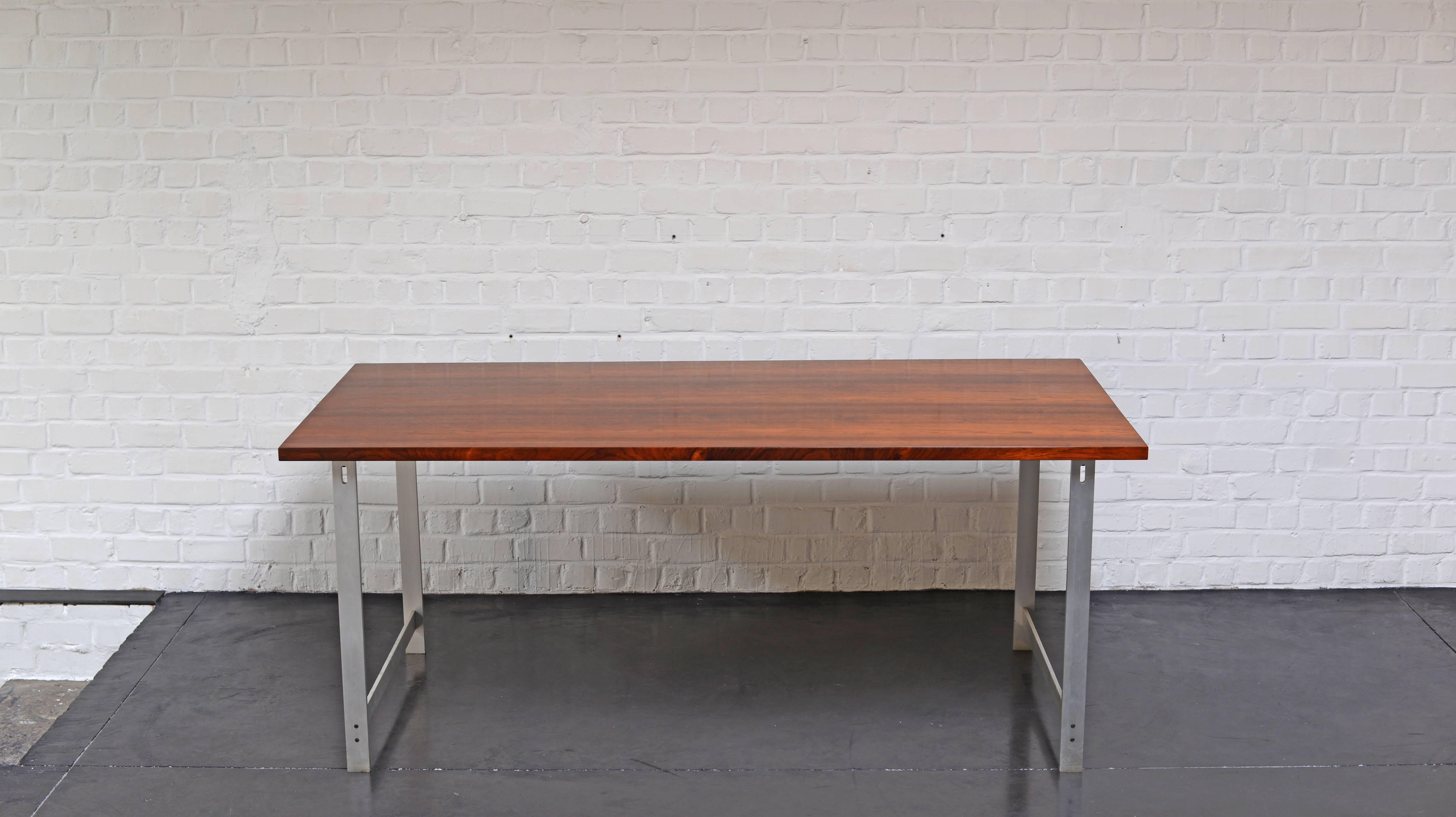Dining table or desk designed by the Danish designer Jørgen Hoj for Niels Vitsoe. Designed in 1962. The aluminum frame have a very nice detail where the screw fix the feet and the top. The tabletop have an amazing rosewood veneer with strong grain.