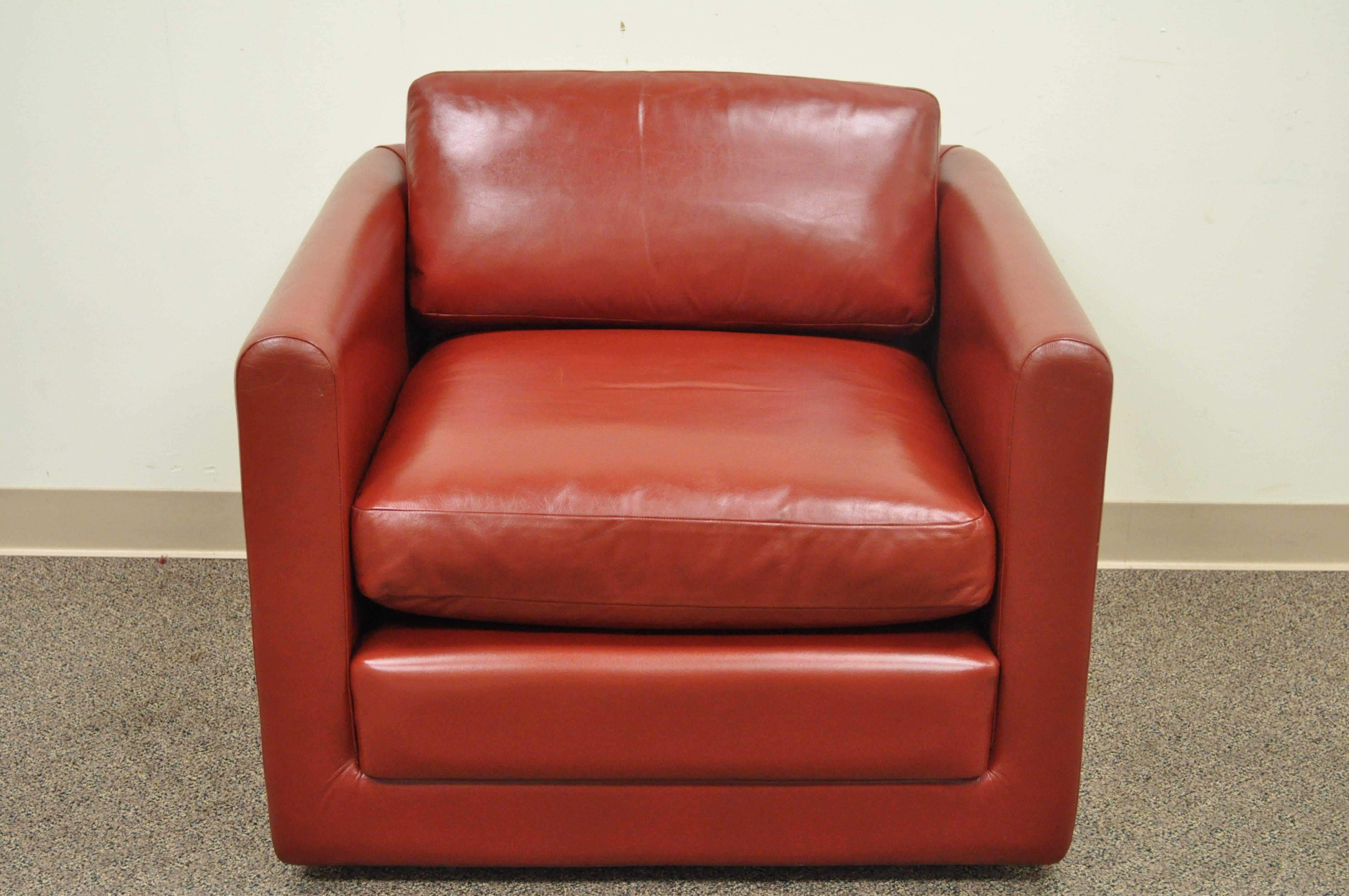 Quality vintage, post Mid-Century Modern, cube form club chair in red leather on rolling casters. The chair features clean lines, comfortable form, solid frame, loose cushions and great functionality. The maker is unconfirmed. Arm height is 25