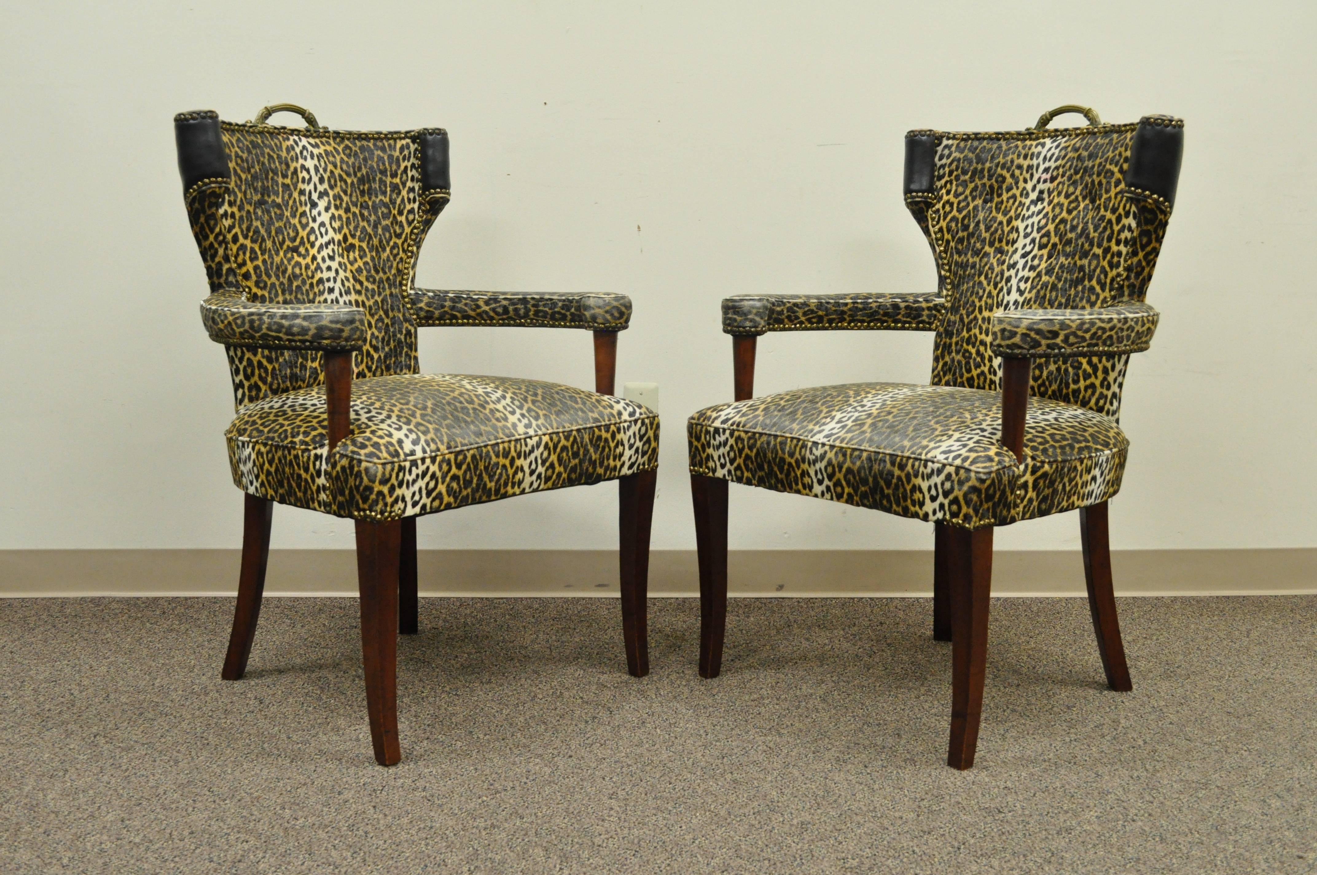 Pair of 1950s Hollywood Regency cheetah or leopard printed vinyl curved back armchairs attributed to Dorothy Draper. Item features mahogany wood frames, brass handles, curved backs, nailhead trim, and great form.