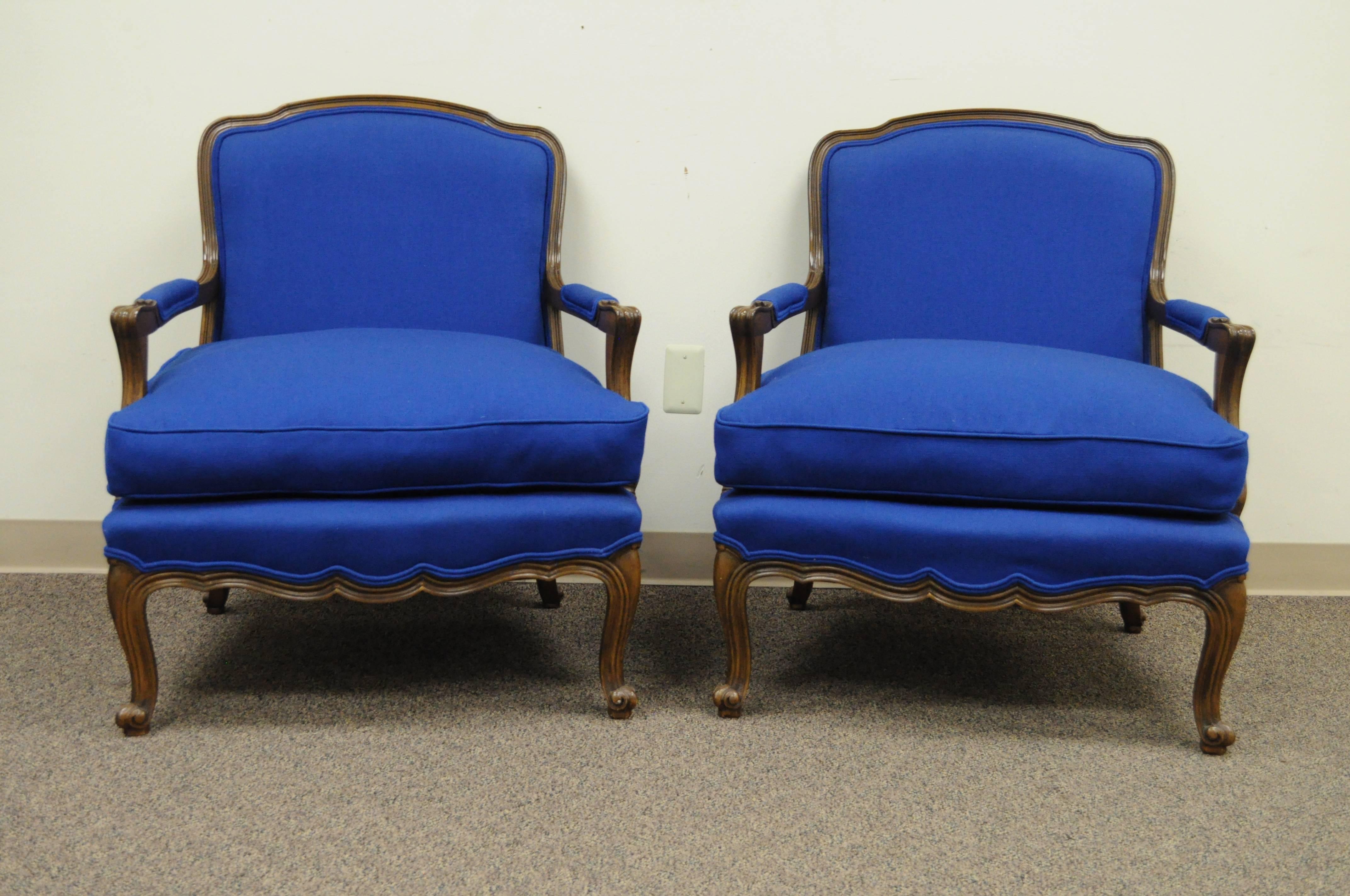 Pair of original blue upholstered Bergeres made for B. Altman & Co by Baker Furniture Co in the Country French / Louis XV Style. This quality pair of armchairs features solid walnut frames, cabriole legs, shaped lower rail, and Classic French form.