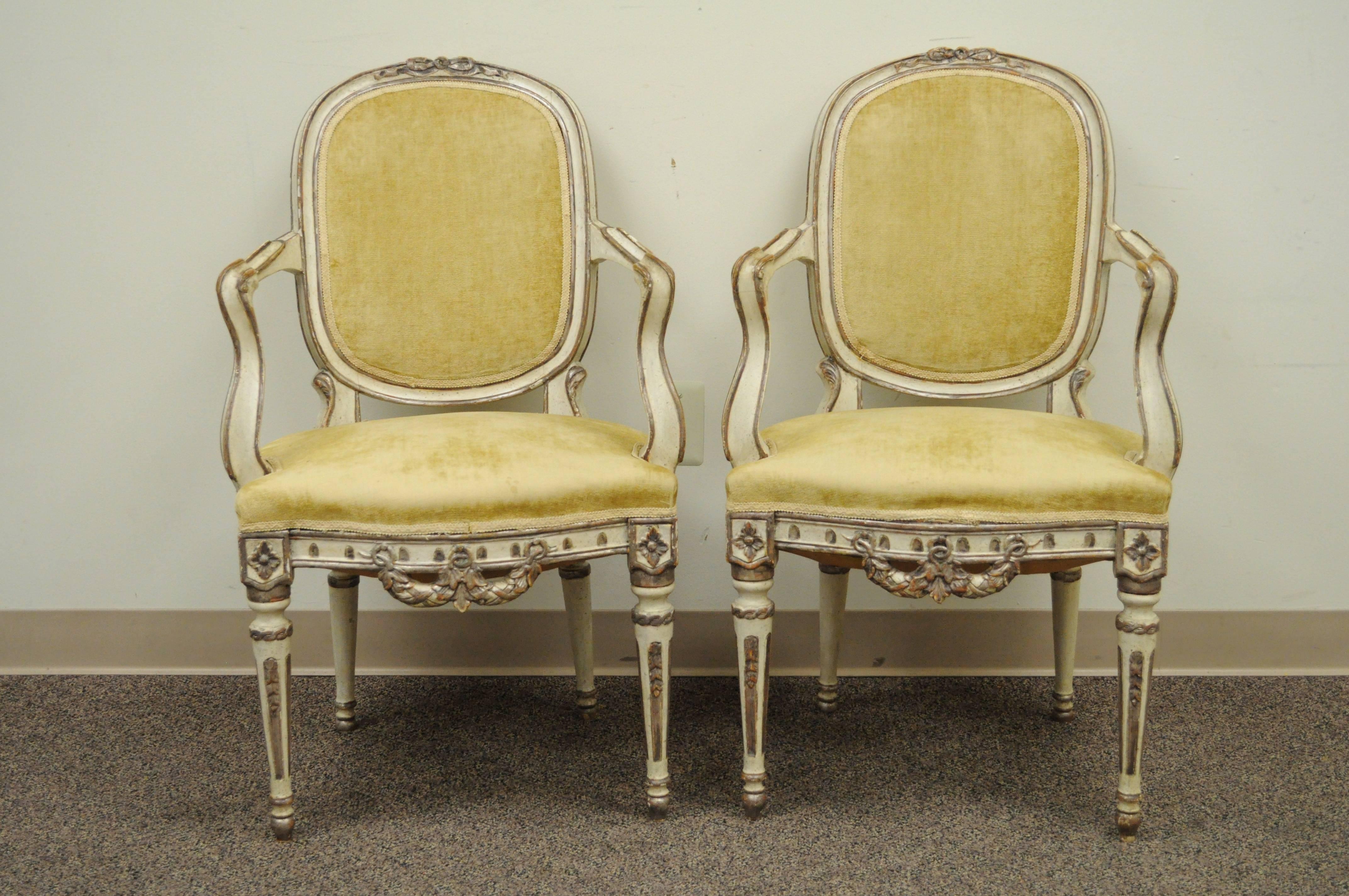 Remarkable pair of Italian hand-carved Fauteuils, circa late 1800s in the French Louis XVI taste. The pair features shapely scrolling arms, medallion backs, reeded and tapered legs, bow and drape carved pediment and lower rail, and a beautiful