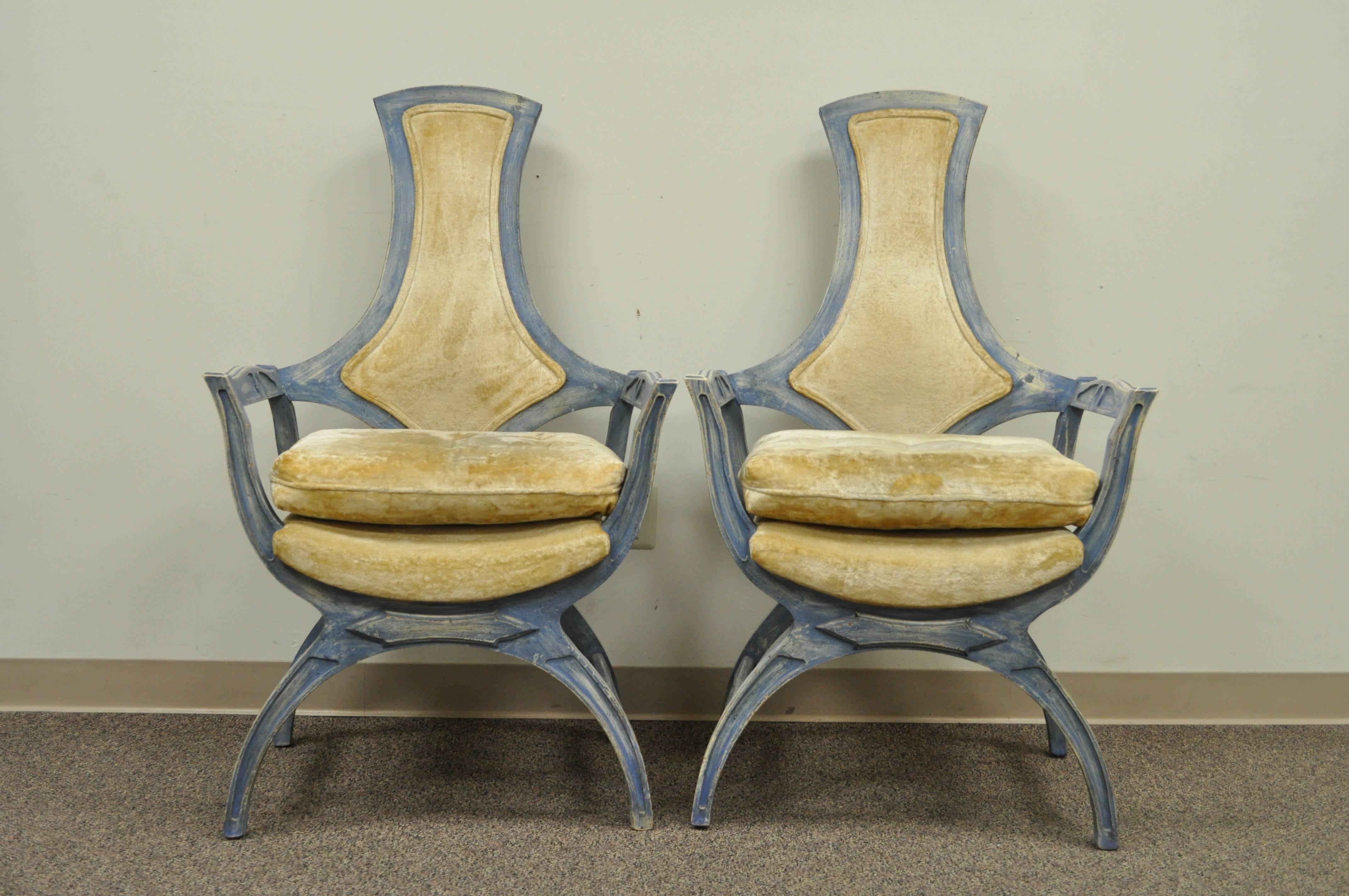 Unique pair of vintage Hollywood Regency Curule or X-form armchairs with a desirable and original blue distress painted finish. The pair features shapely carved open frames and stunning lines. The manufacturer is unconfirmed but the style and