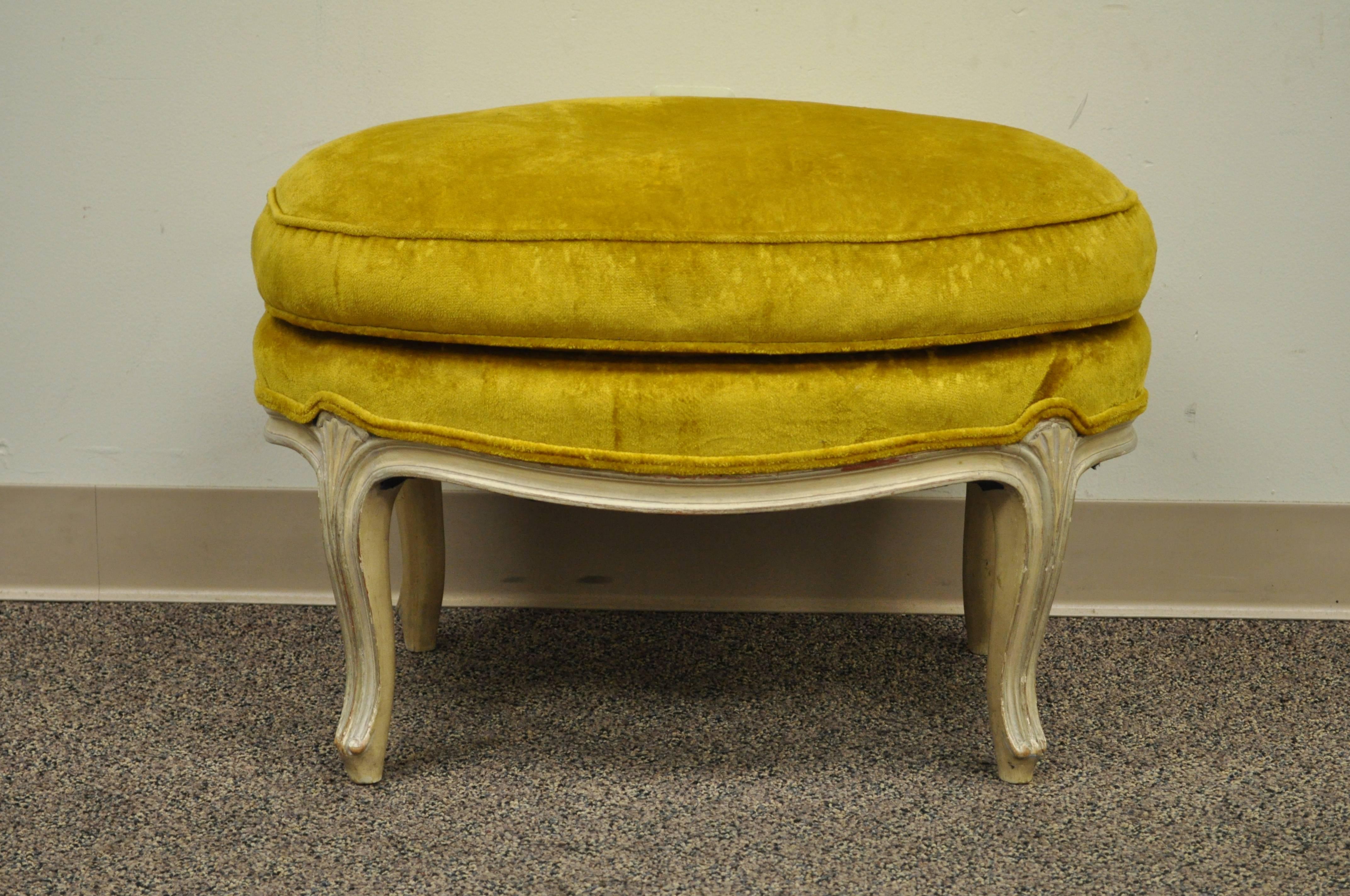 Vintage French Louis XV Style cream painted and gold gilt overstuffed oval shaped ottoman. Item features shapely cabriole legs and shell carved knees.
