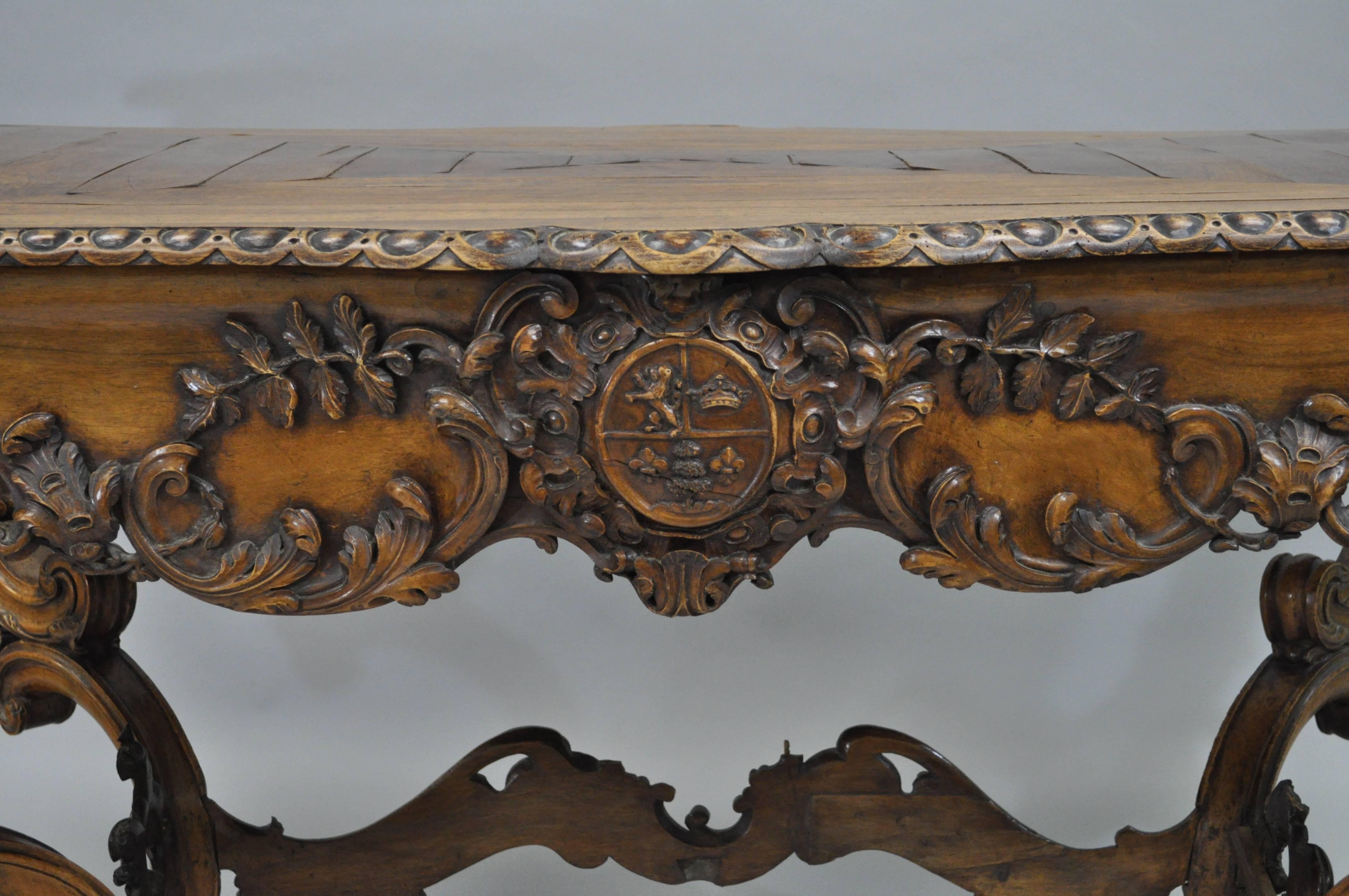 Ornate early 19th century Italian baroque carved walnut center table in the French Louis XV taste. Table features an impressive overall form with fine carvings throughout including the shapely acanthus form legs, stretcher base, plank inlaid walnut