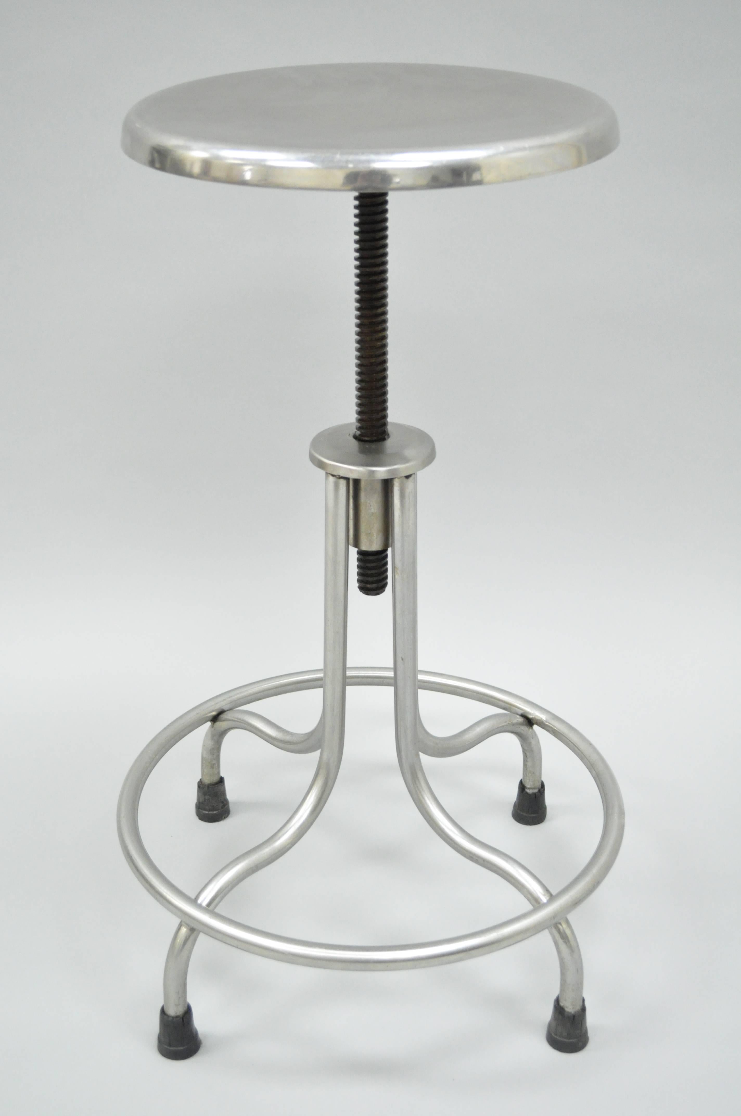 Original vintage stainless steel swivel adjustable height stool / bar stool with footrest by Atlantic Alloy Industries Inc. (AAI) of Union, New Jersey. This well-constructed American made medical or dental stool features a polished solid steel metal
