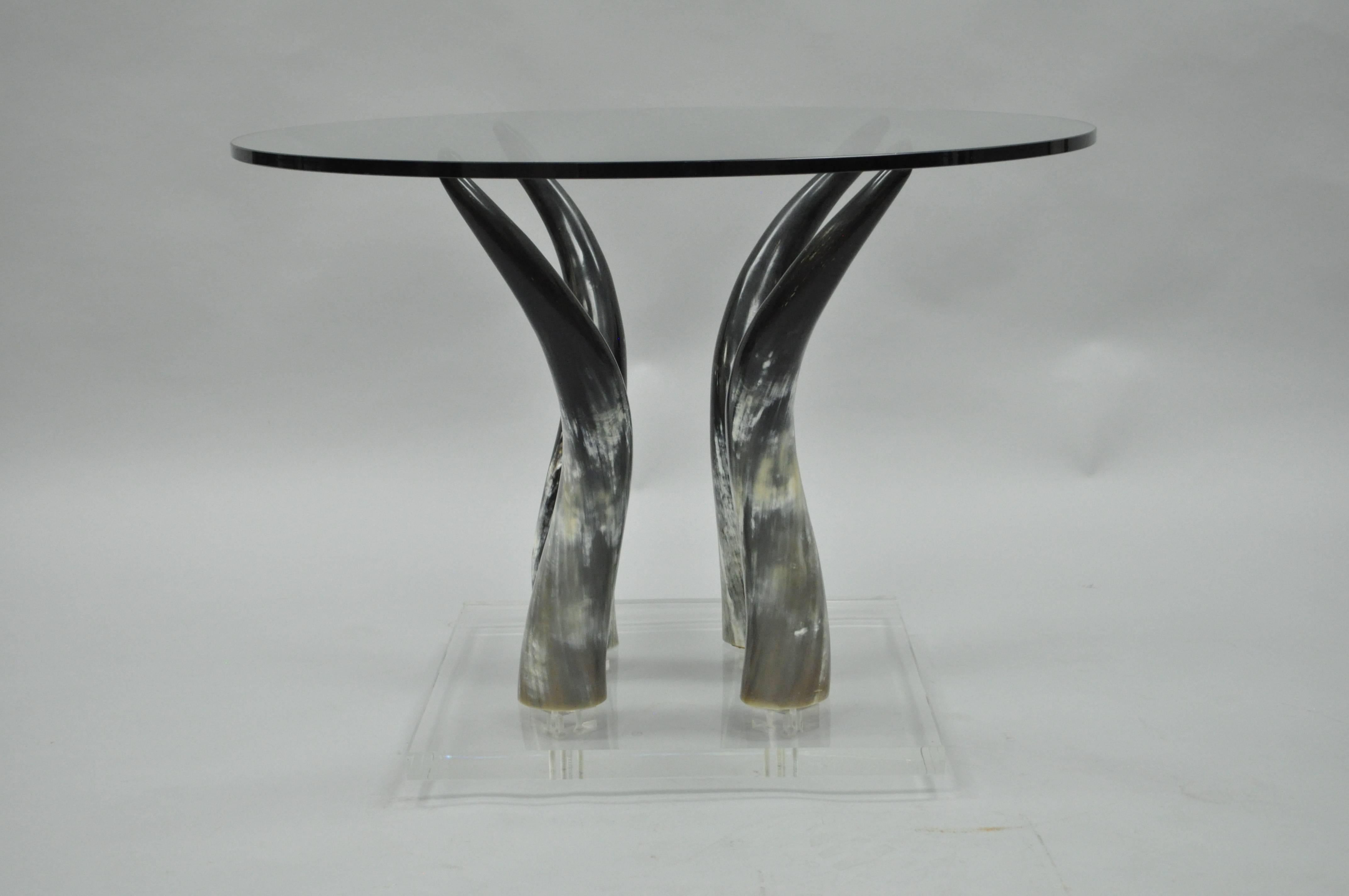Very unique vintage Mid-Century Modern Lucite, glass and Horn occasional side table. Item features a round glass top, four faux Horn supports raised on a Lucite floating form base.