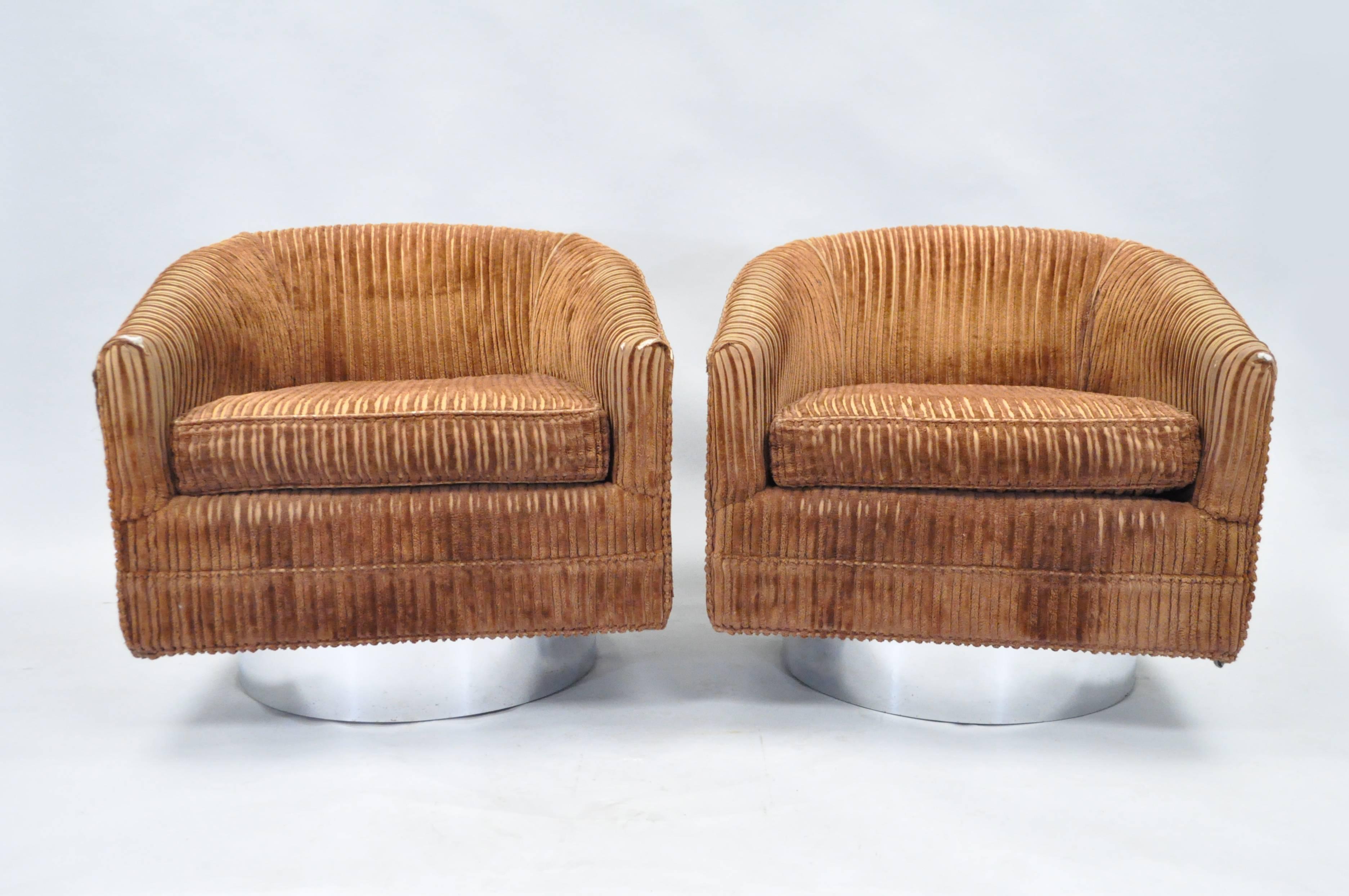 Pair of vintage Mid-Century Modern chrome base swivel club chairs attributed to Milo Baughman for Thayer Coggin. This original pair of lounge chairs features clean modern lines, barrel backs with the uppers raised on swiveling chrome trimmed plinths.