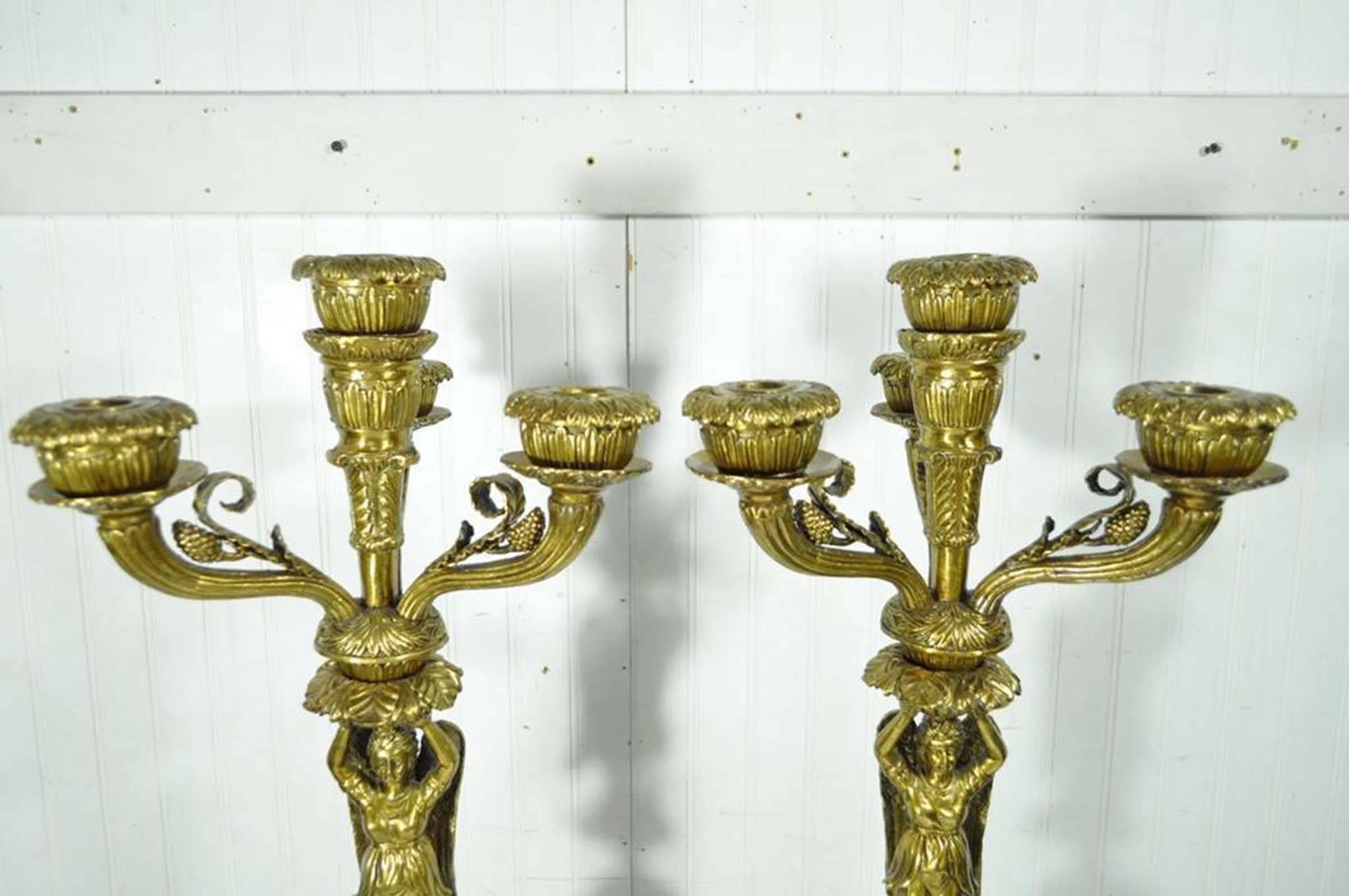 Fantastic pair of heavy, 20th century, reproduction bronze and porcelain figural candelabras in the French neoclassical taste. Each candelabra features four candleholder arms, full winged maiden shafts that stand on neoclassical style spheres which