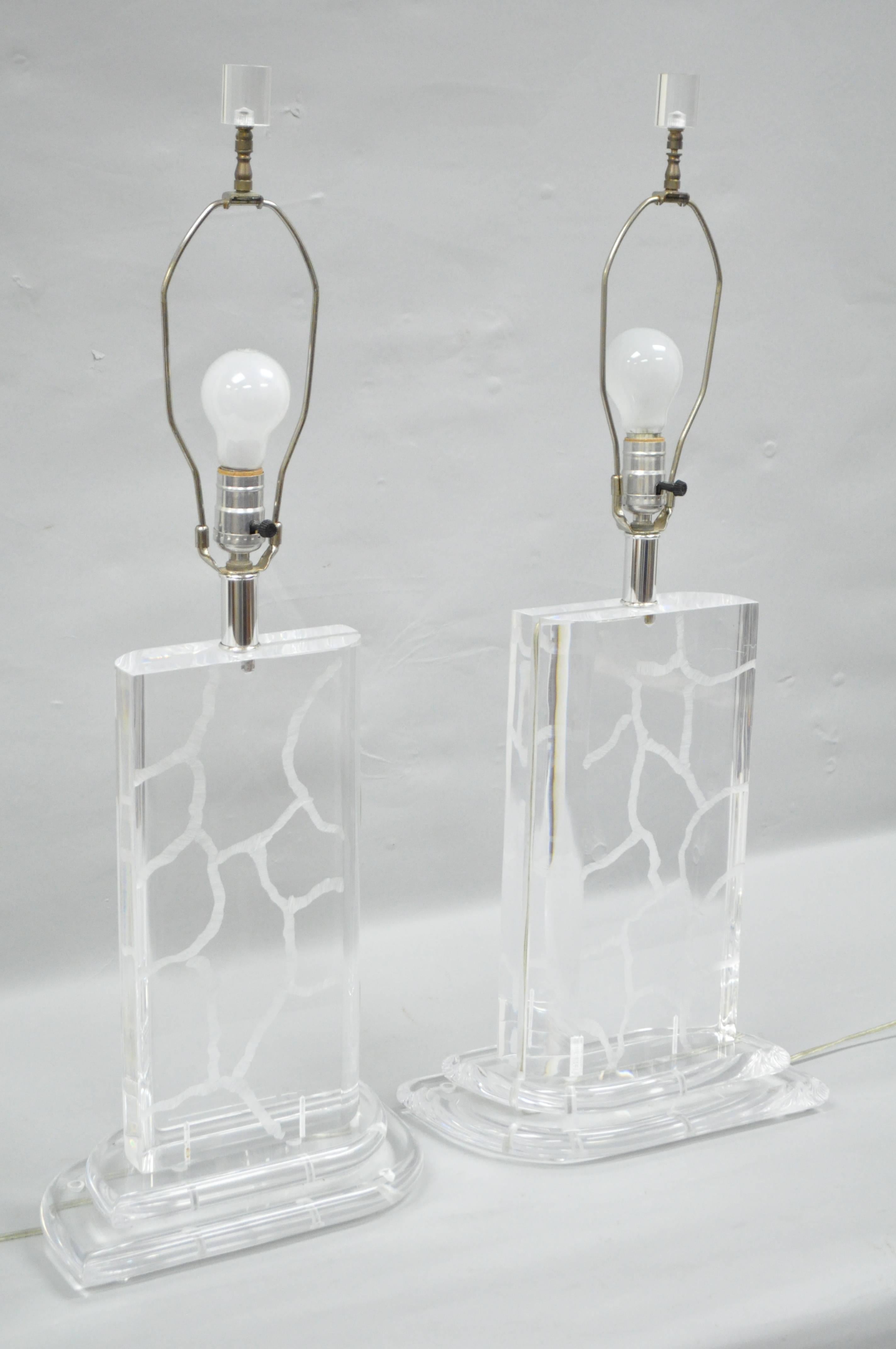 Pair of van teal Mid-Century Modern or Hollywood Regency clear etch decorated Lucite table lamps. Item features solid clear Lucite forms with wave or crackle etched design topped off with Lucite finials. Designed By Hivo Van Teal.
Measurements: 32