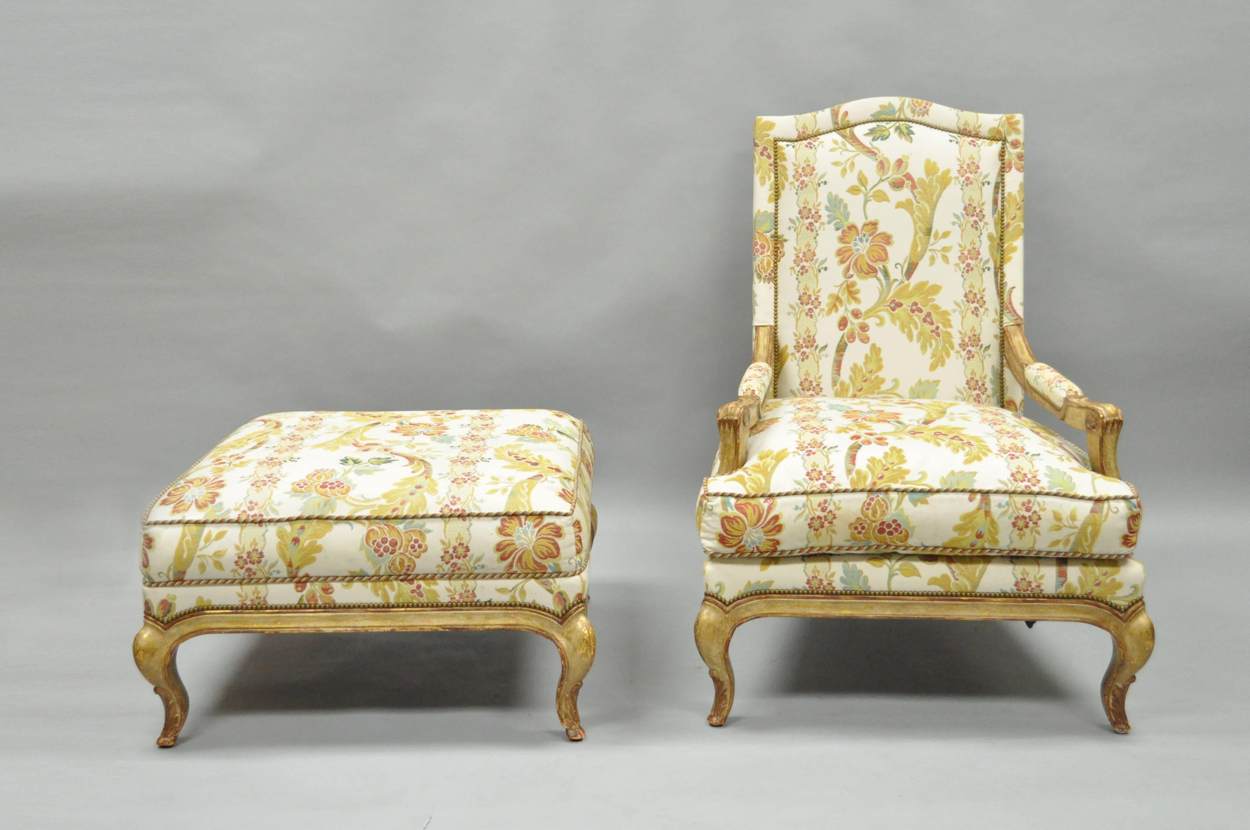 High quality country French / Louis XV style upholstered Bergere lounge chair and matching ottoman by Nancy Corzine. Chair features a stately form with a lightly carved solid wood frame, shapely cabriole legs, and beautiful gold, red, and cream