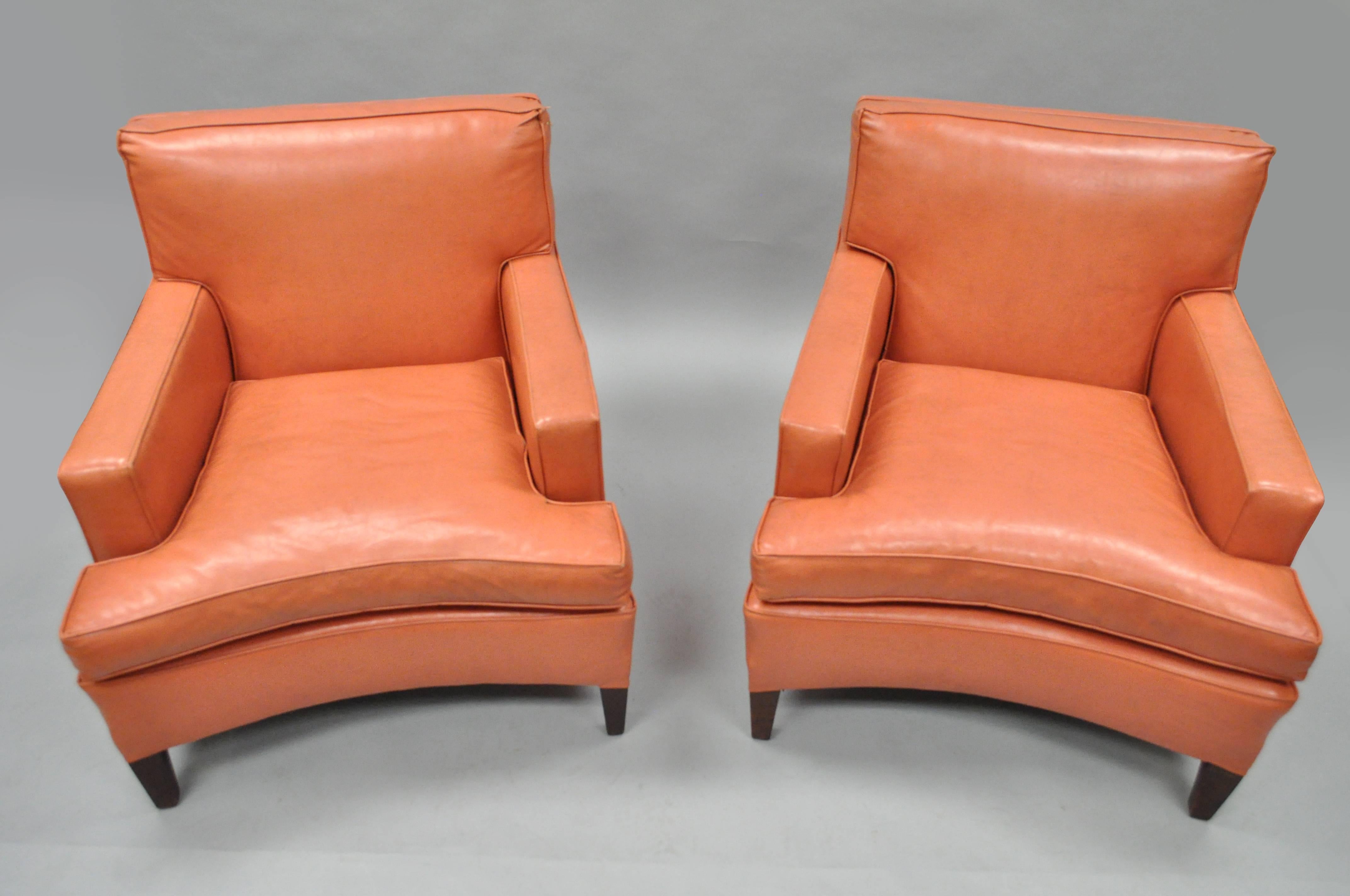 Quality pair of vintage curved front Mid-Century Modern club or lounge armchairs in the manner of Harvey Probber. Chairs feature solid mahogany frames, curved fronts, original coral colored vinyl upholstery and great sculptural modernist lines.