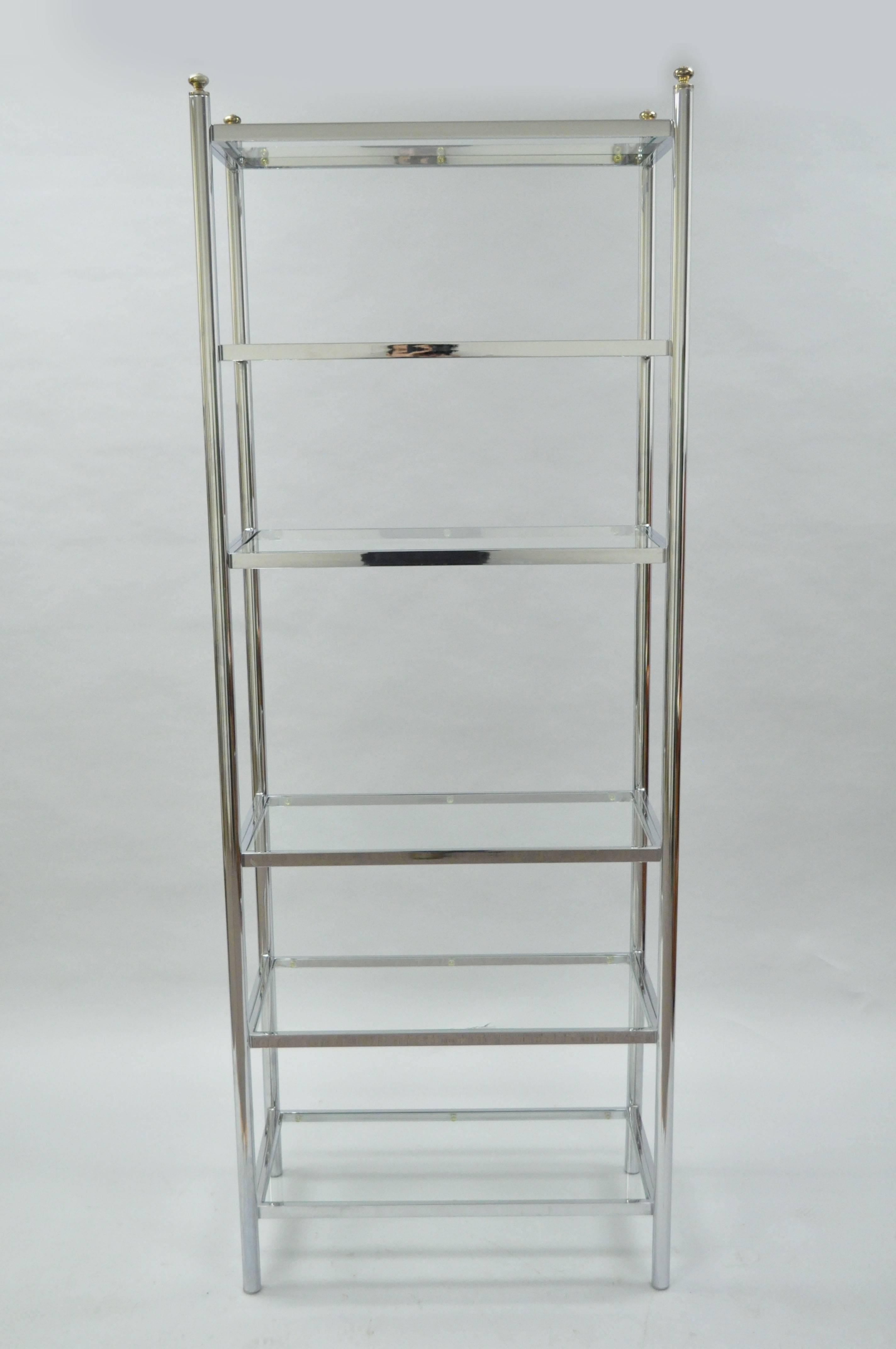 Vintage Mid-Century Modern polished chrome and glass six shelf tall and narrow étagère bookcase. Item features six inset glass shelves (including the top shelf), brass finials, clean modernist lines, great quality and form. In the Maison Jansen