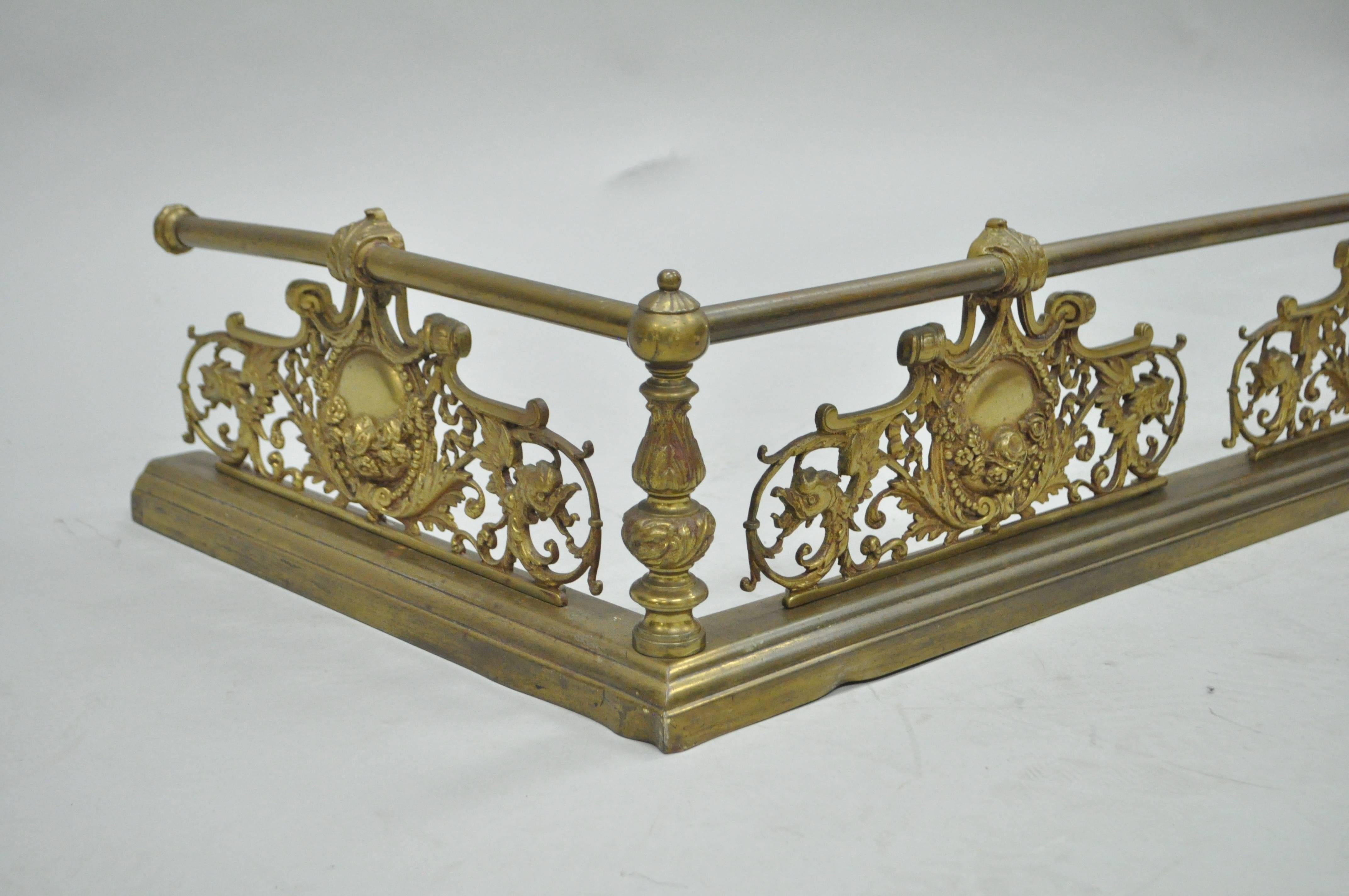 Stunning antique French Victorian gilt brass floral drape motif fireplace fender. Item features a substantial form with cast brass figural ormolu depicting acanthus leaves, drapes, and birds. The overall measurements are 7
