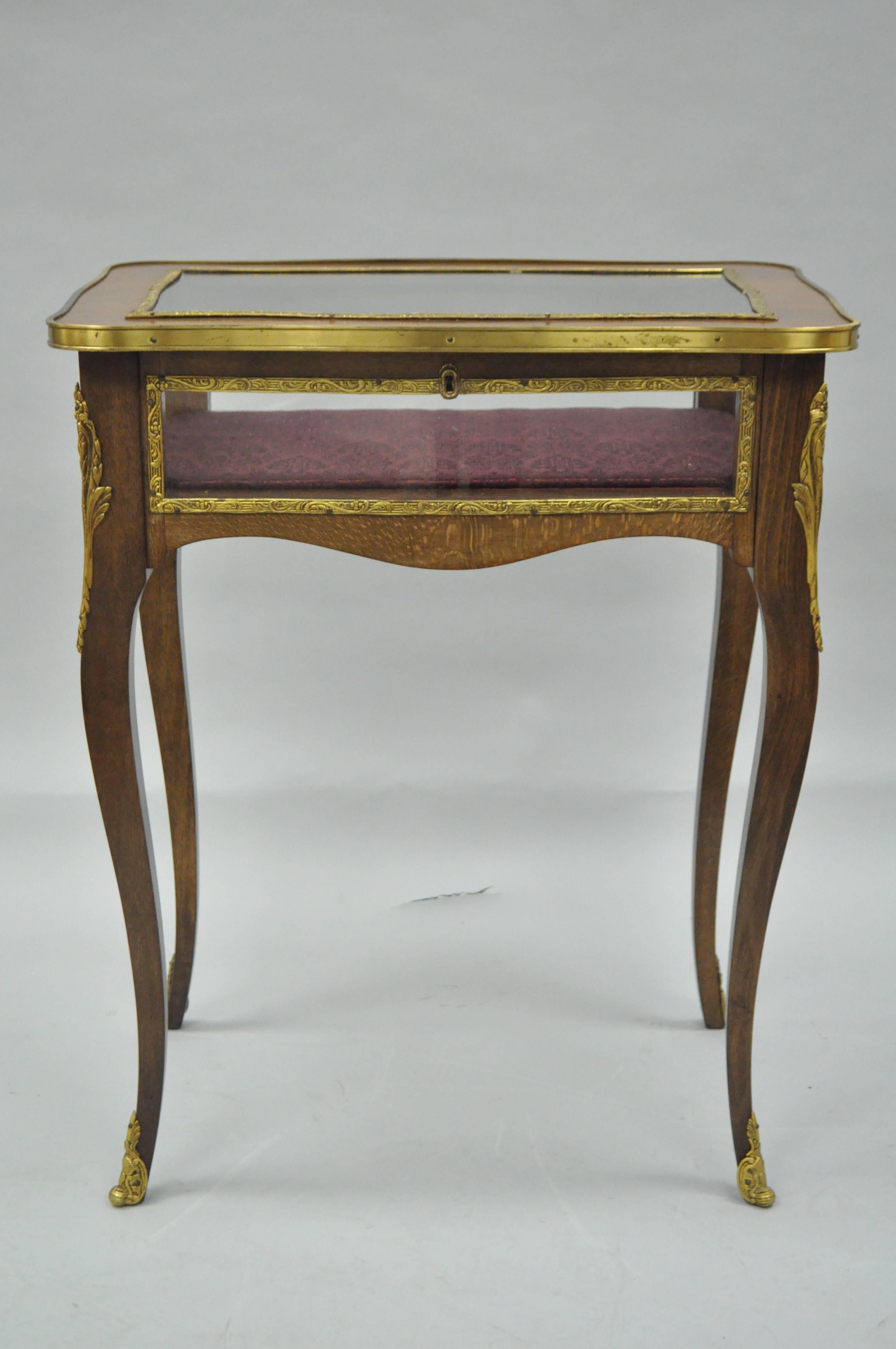 Attractive vintage French Louis XV style flip-top display accent table. Item features cast brass ormolu, glass flip-top, glass sides, shapely cabriole legs, and upholstered interior. Marked 