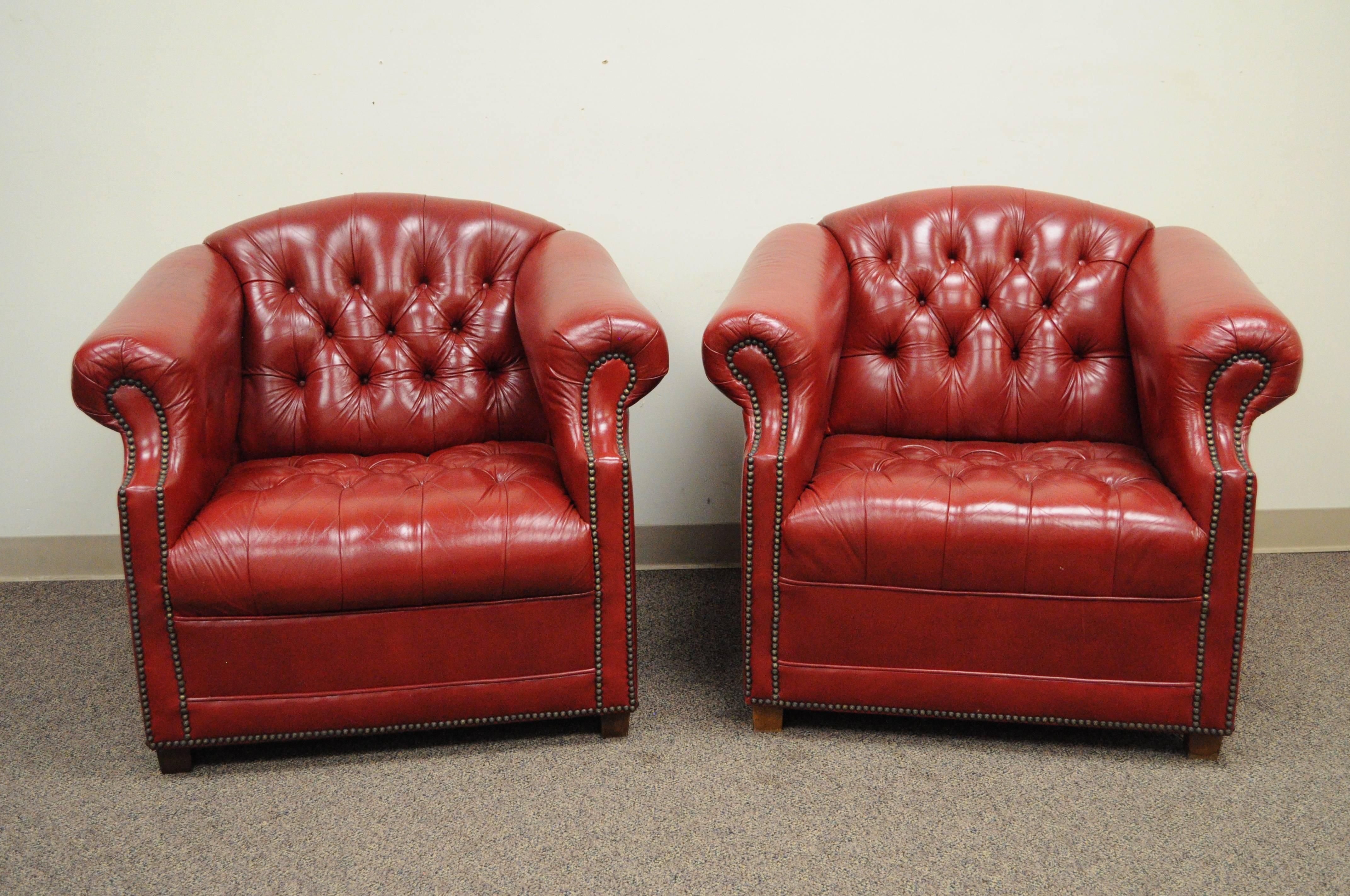 Pair of American made red leather English chesterfield style tufted club chairs by Jasper Seating Oo. Chairs feature deep red leather upholstery, rolled arms, nailhead trim, wooden feet, great form. 30